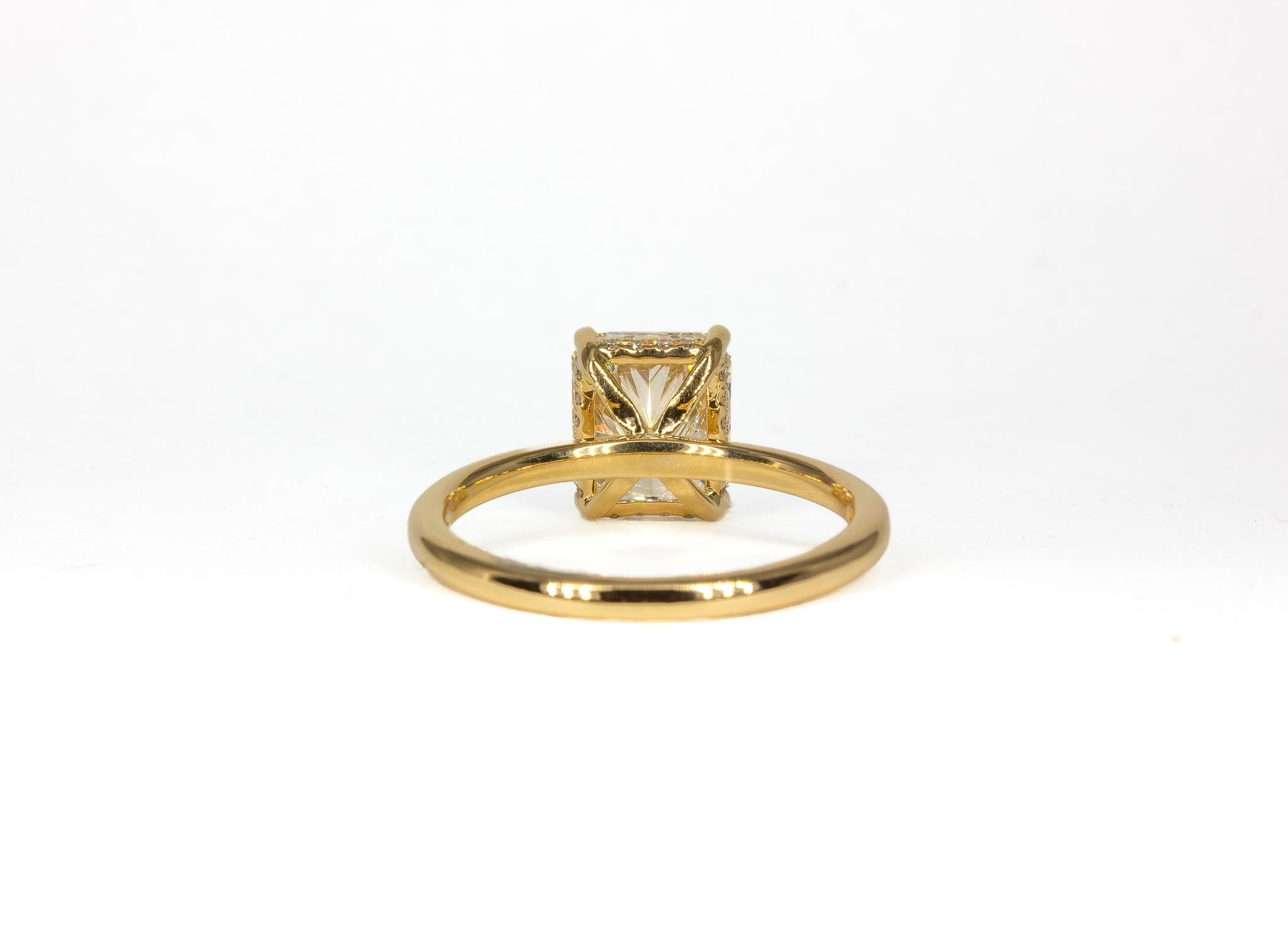 This exquisite 14K yellow gold solitaire ring showcases a breathtaking 2.73 carat radiant cut diamond, GIA certified G color and VVS1 clarity. The remarkable center stone is expertly set in a classic four-prong setting, allowing maximum light to