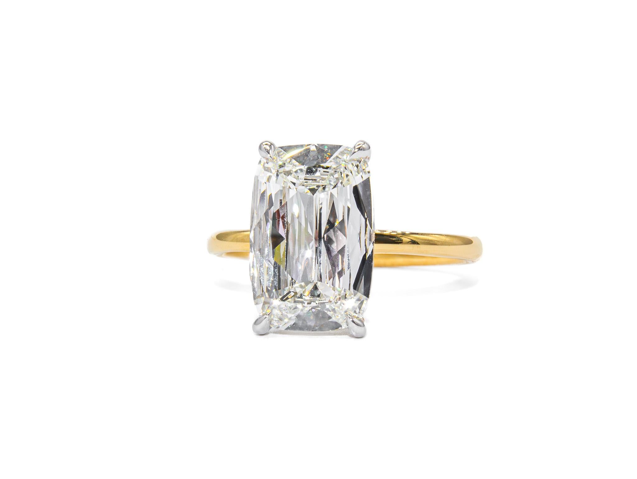 This exquisite platinum and 18K yellow gold solitaire ring showcases a breathtaking 3.03 carat cushion brilliant diamond (I VS2, GIA), offering exceptional brilliance and timeless elegance. The center diamond's soft, rounded edges and captivating