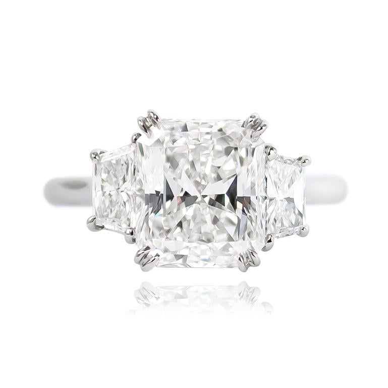 This scintillating three-stone ring from the J. Birnbach collection features a GIA certified 3.08 ct Radiant cut diamond of F color and VS1 clarity. Set in a handmade platinum ring with brilliant cut trapezoid side stones = 0.77 ctw, this piece is a