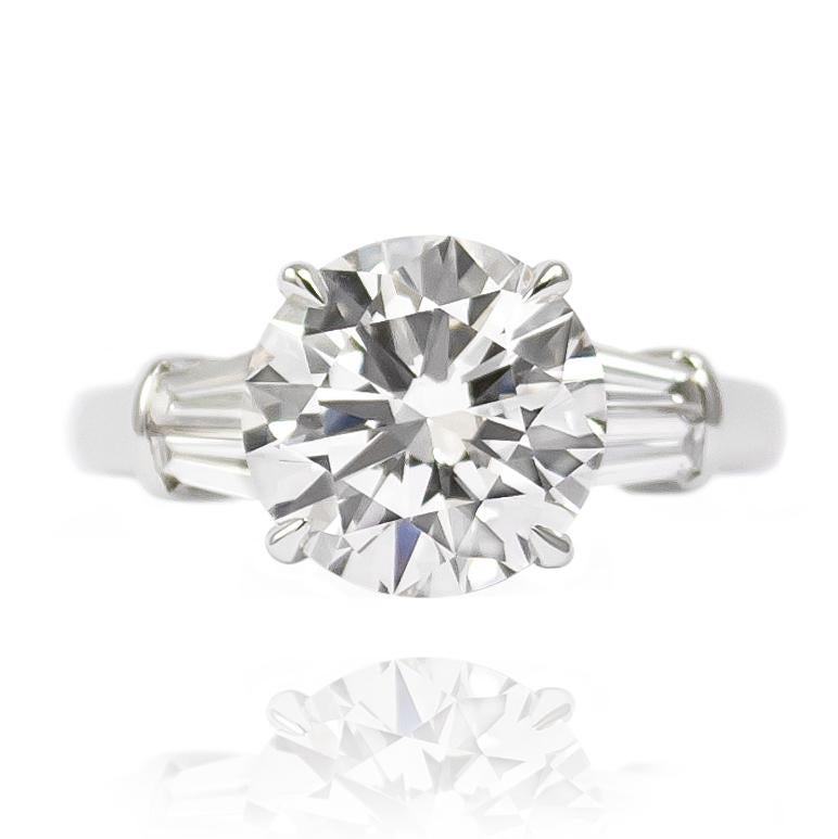 This timeless classic features a GIA Certified 3.38 ct Brilliant Round Diamond set into a beautiful platinum mounting with 4 tapered baguettes = 0.68 ctw. 

Original purchase includes original GIA Certificate No. 2141886226 which states that this