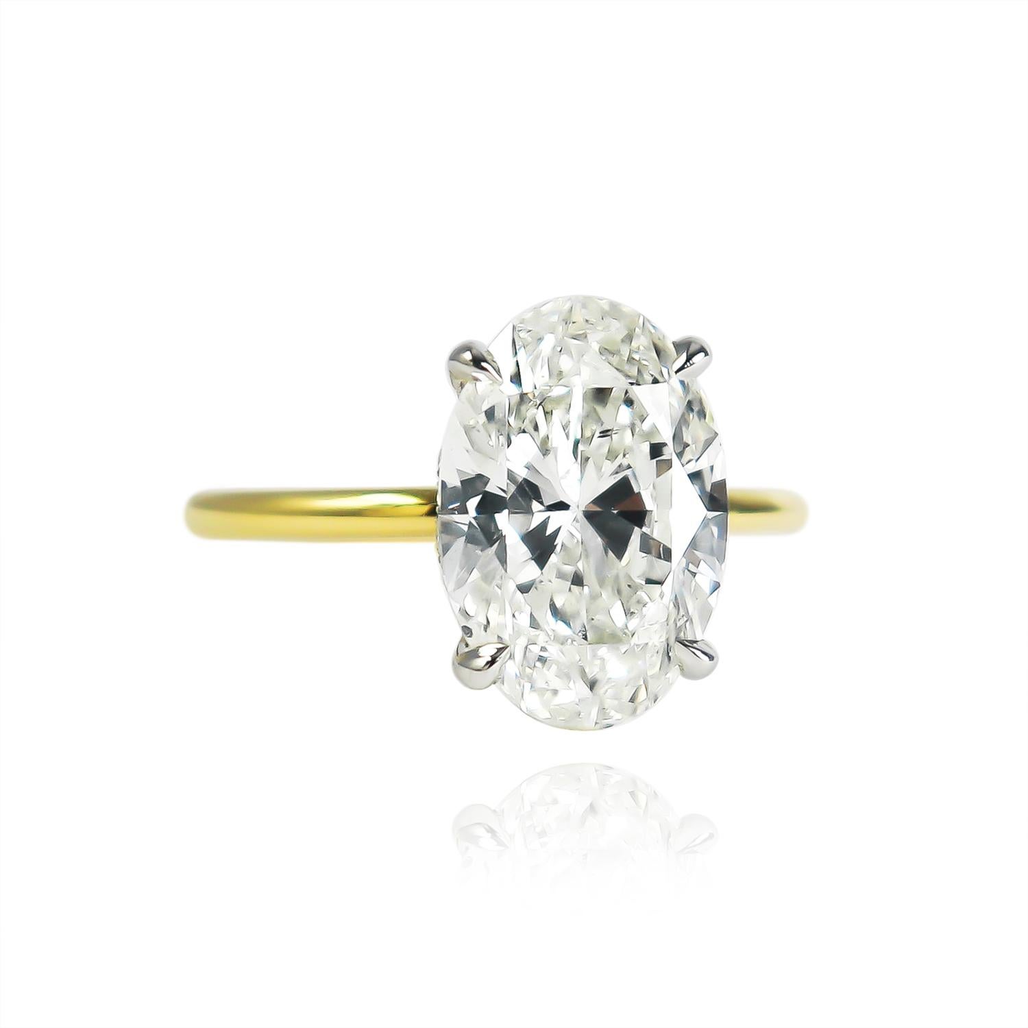 This breathtaking and delicate ring fresh from the J. Birnbach workshop features a GIA certified 3.58 carat oval brilliant cut diamond of J color and SI1 clarity. Set in a handmade, 18K yellow gold and platinum solitaire ring with a hidden halo