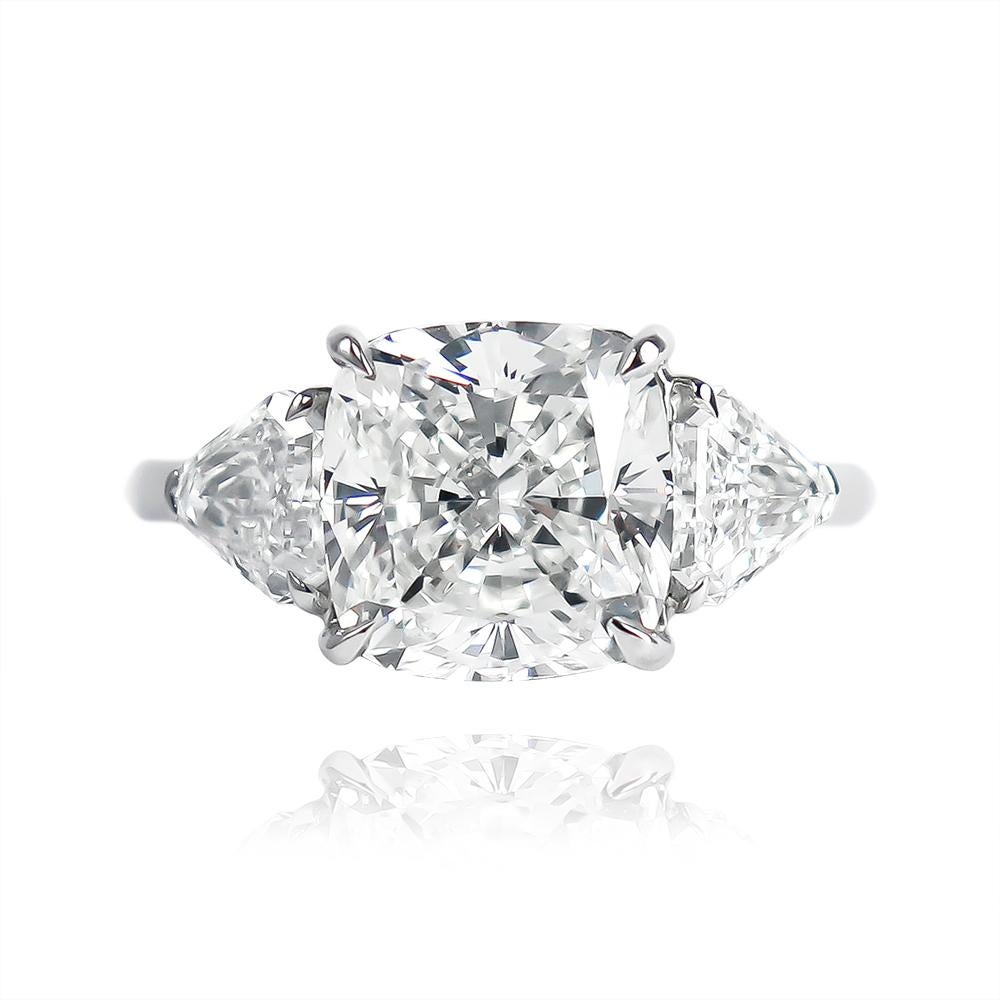 This scintillating ring features a 3.71 carat cushion modified brilliant cut diamond of I color and VS1 clarity... Set in a handmade, platinum, three-stone ring with shield side stones = 0.85 ctw, this piece is contemporary, bold, and beautiful