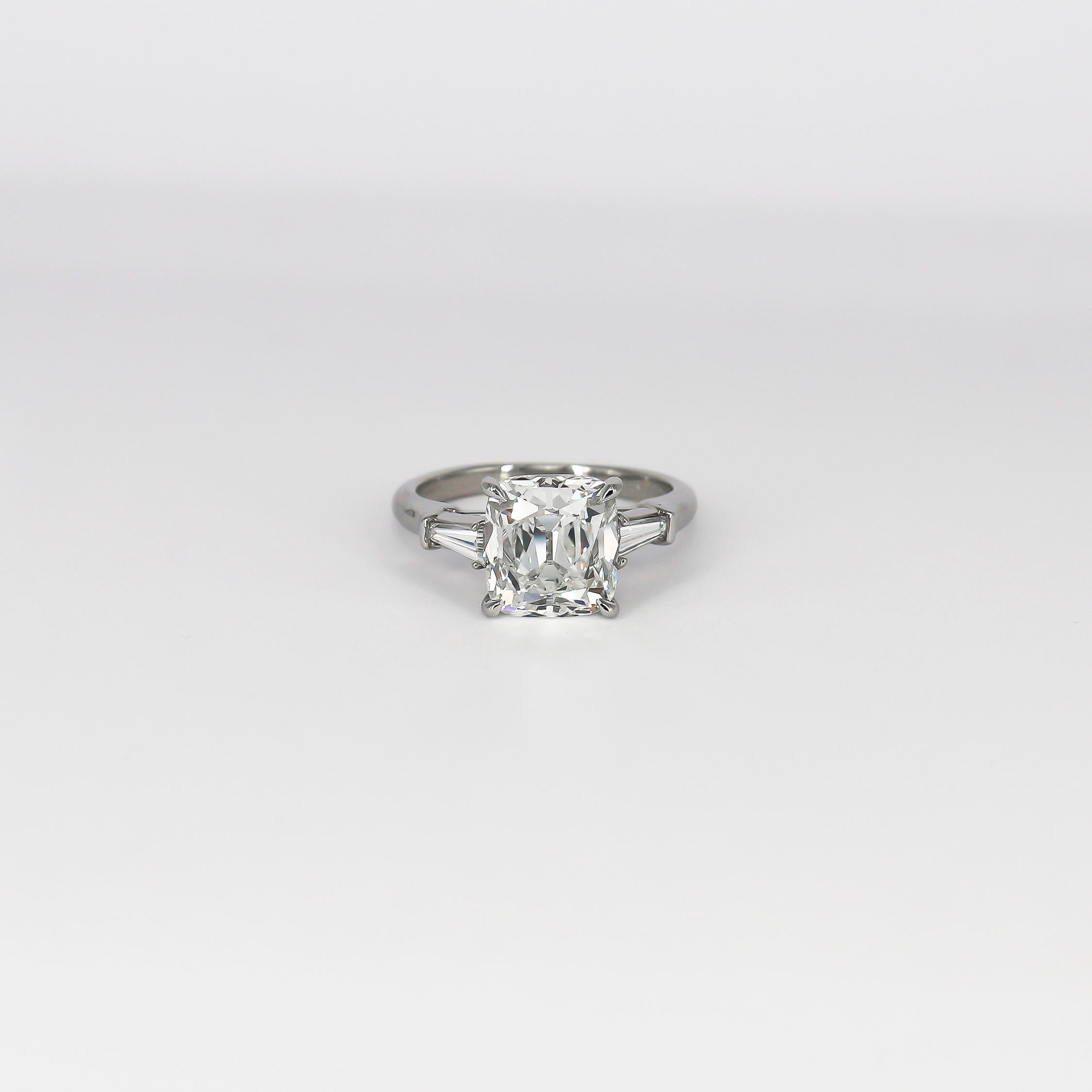 This incredible new piece by the house of J. Birnbach features a GIA certified 4.08 carat old mine cut diamond of J color and VS1 clarity as described by GIA grading report #2201799745. Set in an elegant, platinum, three-stone ring with tapered