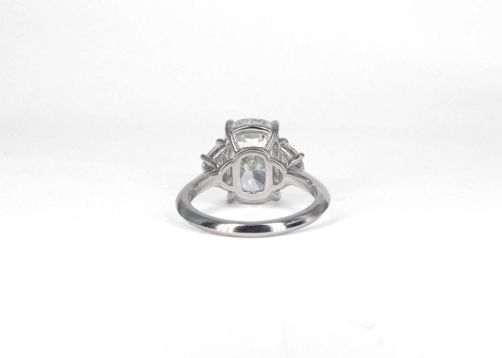 Experience timeless beauty with this GIA Certified 5.02 Carat Cushion Cut Diamond Three-Stone Platinum Ring. Showcasing a stunning 5.02 carat cushion cut center diamond, graded I color and SI1 clarity, this exquisite ring is crafted to capture light