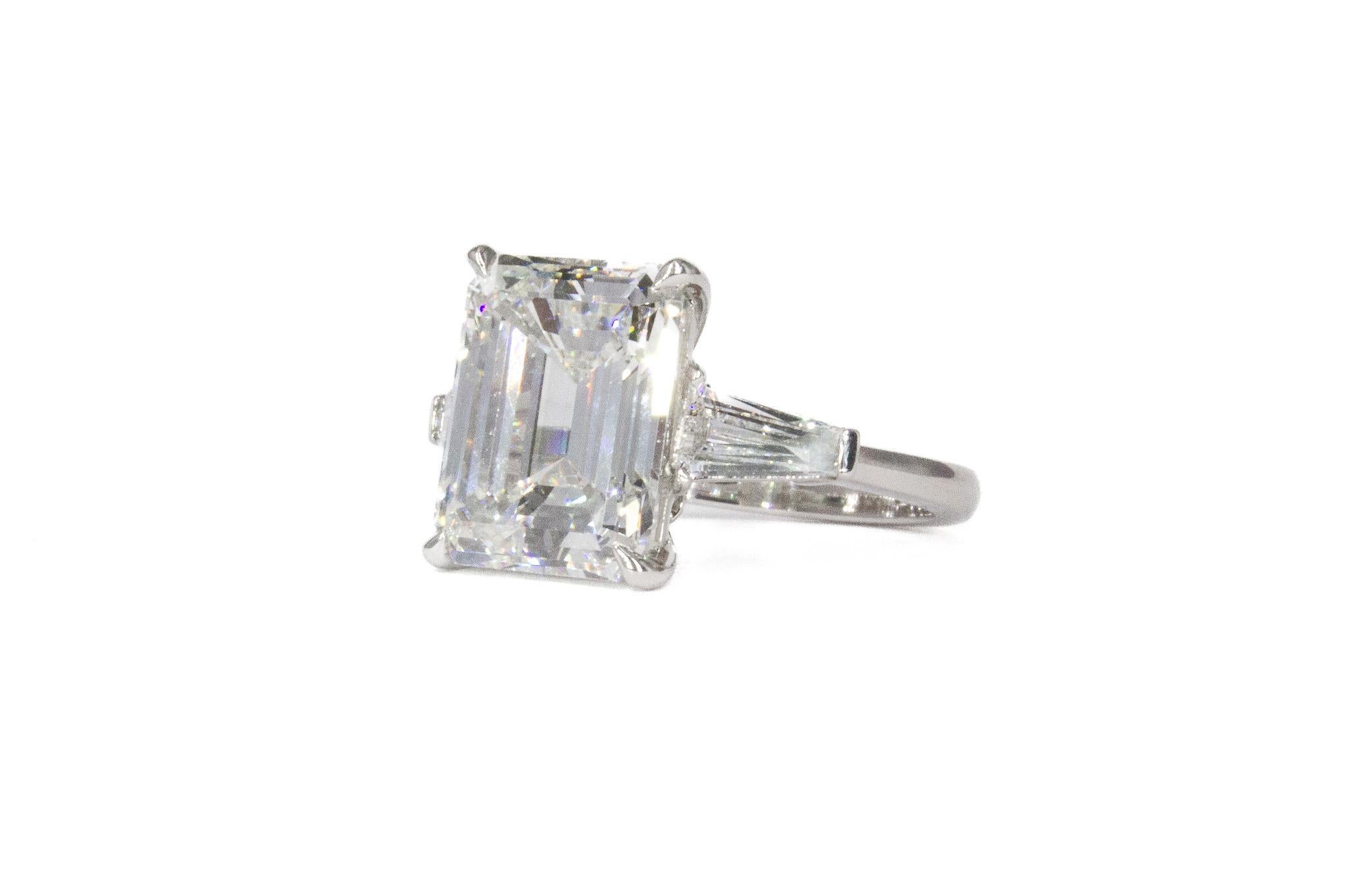 Be mesmerized by our J. Birnbach GIA Certified Emerald Cut Diamond Three-Stone Ring, a true masterpiece of craftsmanship and design. At its heart lies a stunning 5.49 carat emerald-cut diamond, GIA certified with H color and SI2 clarity, offering