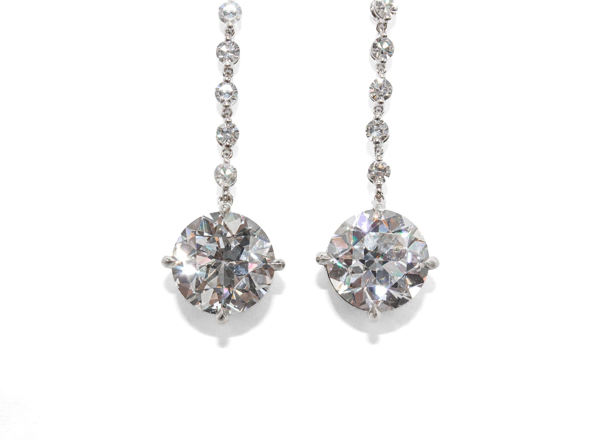 Ces exquises boucles d'oreilles pendantes en or blanc 18 carats mettent en valeur une paire de diamants de taille européenne à couper le souffle, exhalant une élégance intemporelle et un savoir-faire artisanal exceptionnel. Les boucles d'oreilles