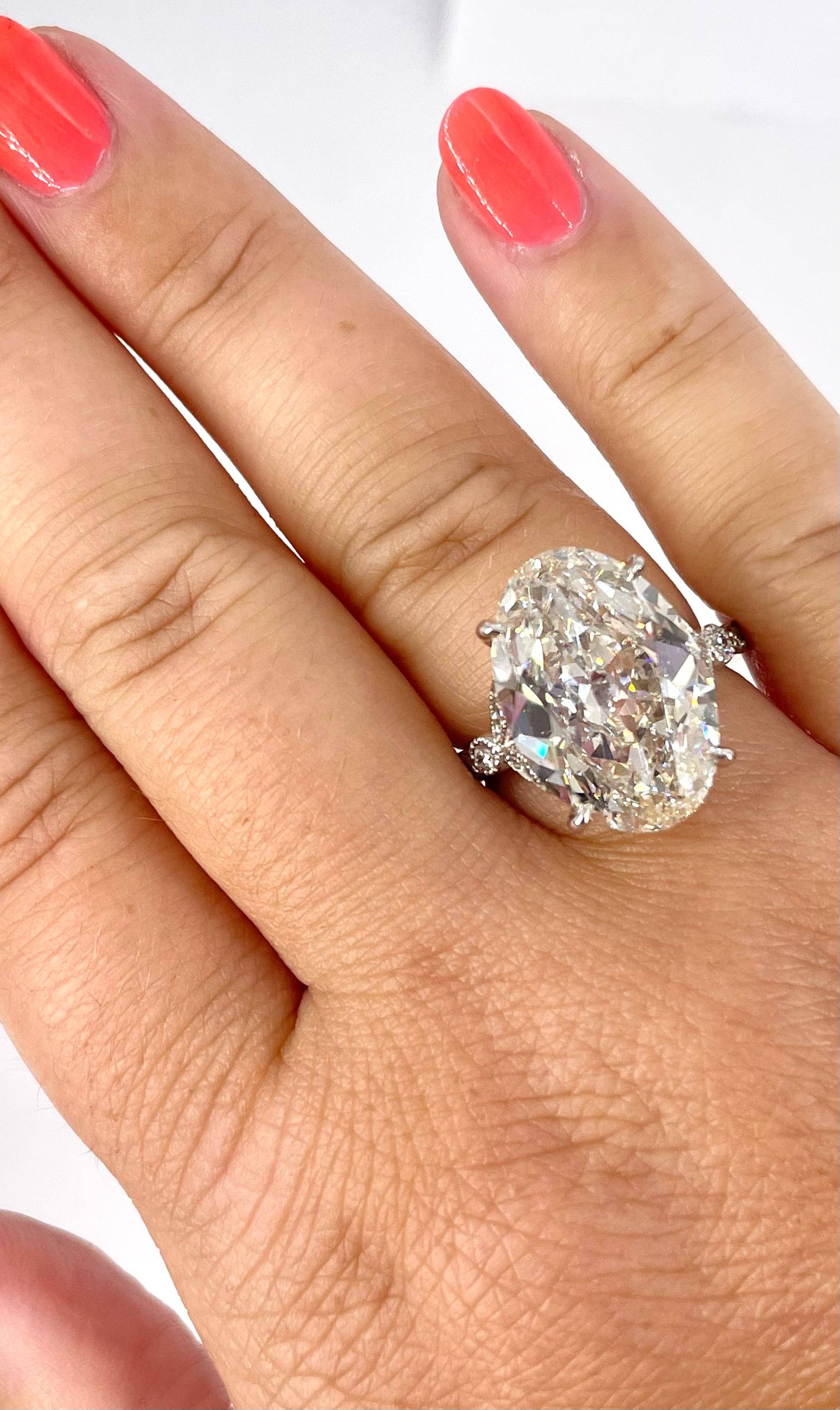 This romantic, antique inspired engagement ring by J. Birnbach features a gorgeous 8.56 carat oval diamond. The center diamond is GIA certified as J color and SI1 clarity. The platinum setting features milgrain and pave details create a feminine,