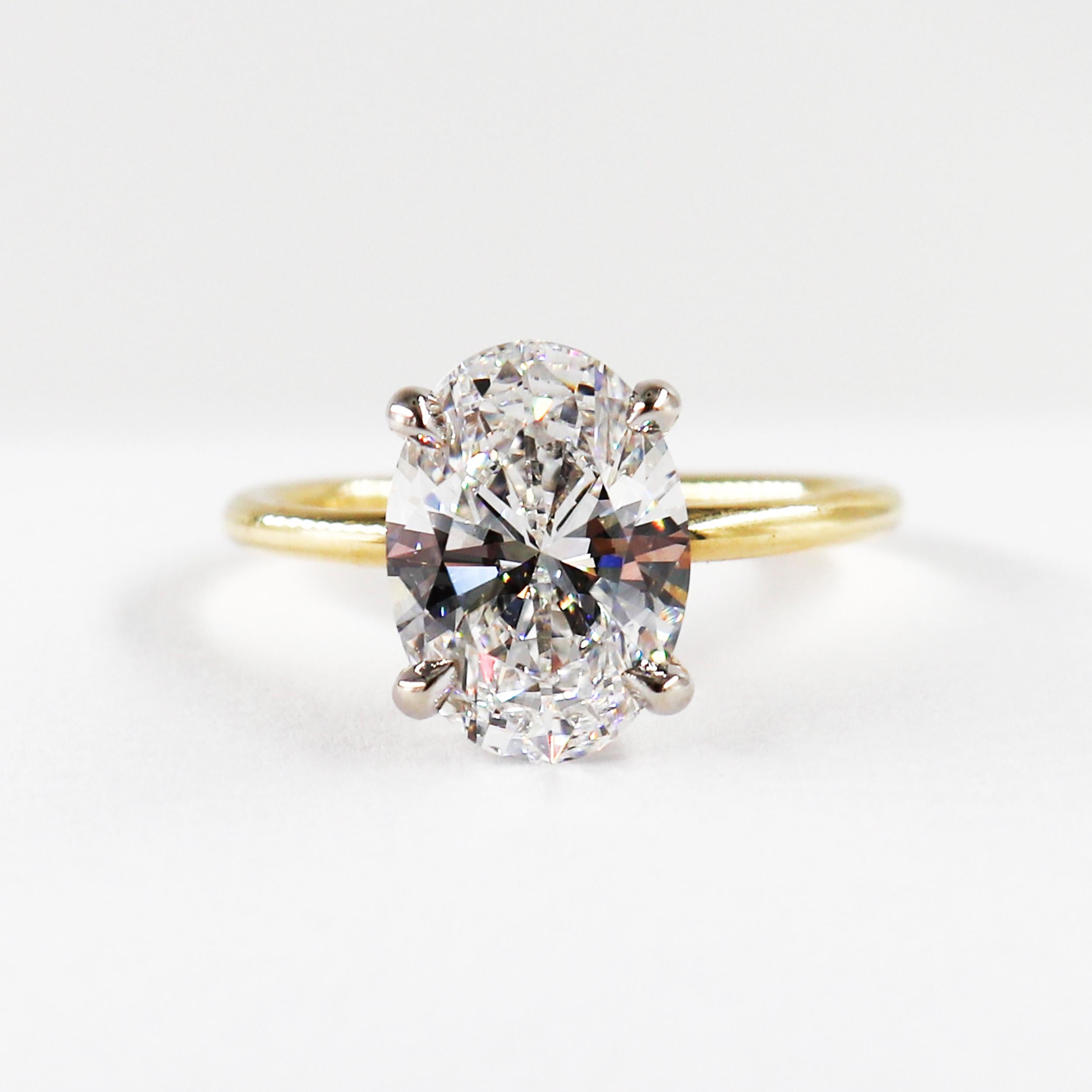 This classy J. Birnbach solitaire ring features a 3.03 carat Oval Cut GIA Certified diamond with E color and IF clarity. The Diamond is set in a rounded 18 Karat Yellow gold mounting with platinum prongs with a discreet and elegant hidden pave