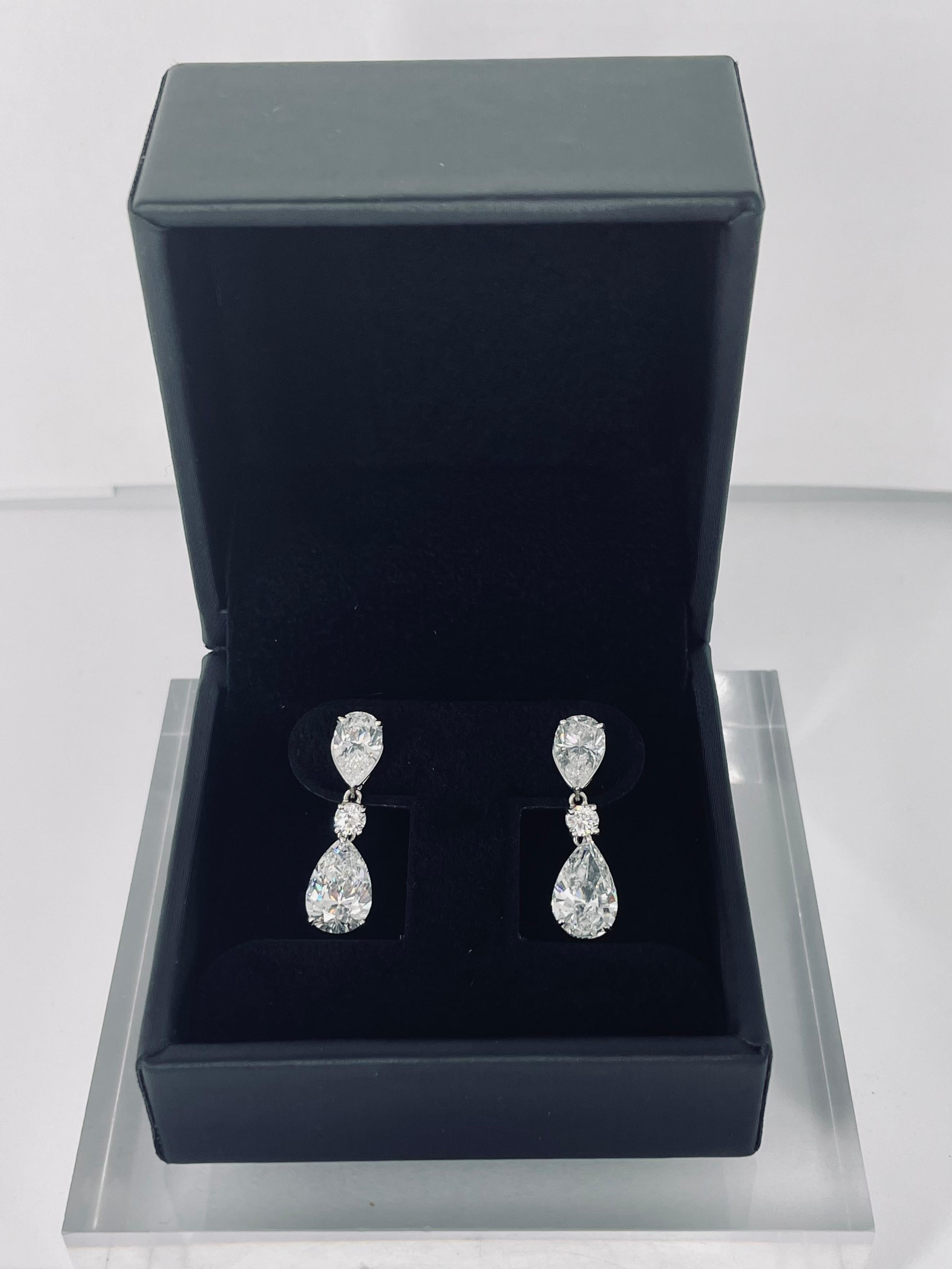 Elegant and timeless, these stunning earrings by J. Birnbach are the perfect piece for a bride or for a black tie event. The earrings are composed of a pear shape diamond on the ear, a small round diamond, then a larger pear diamond drop. The