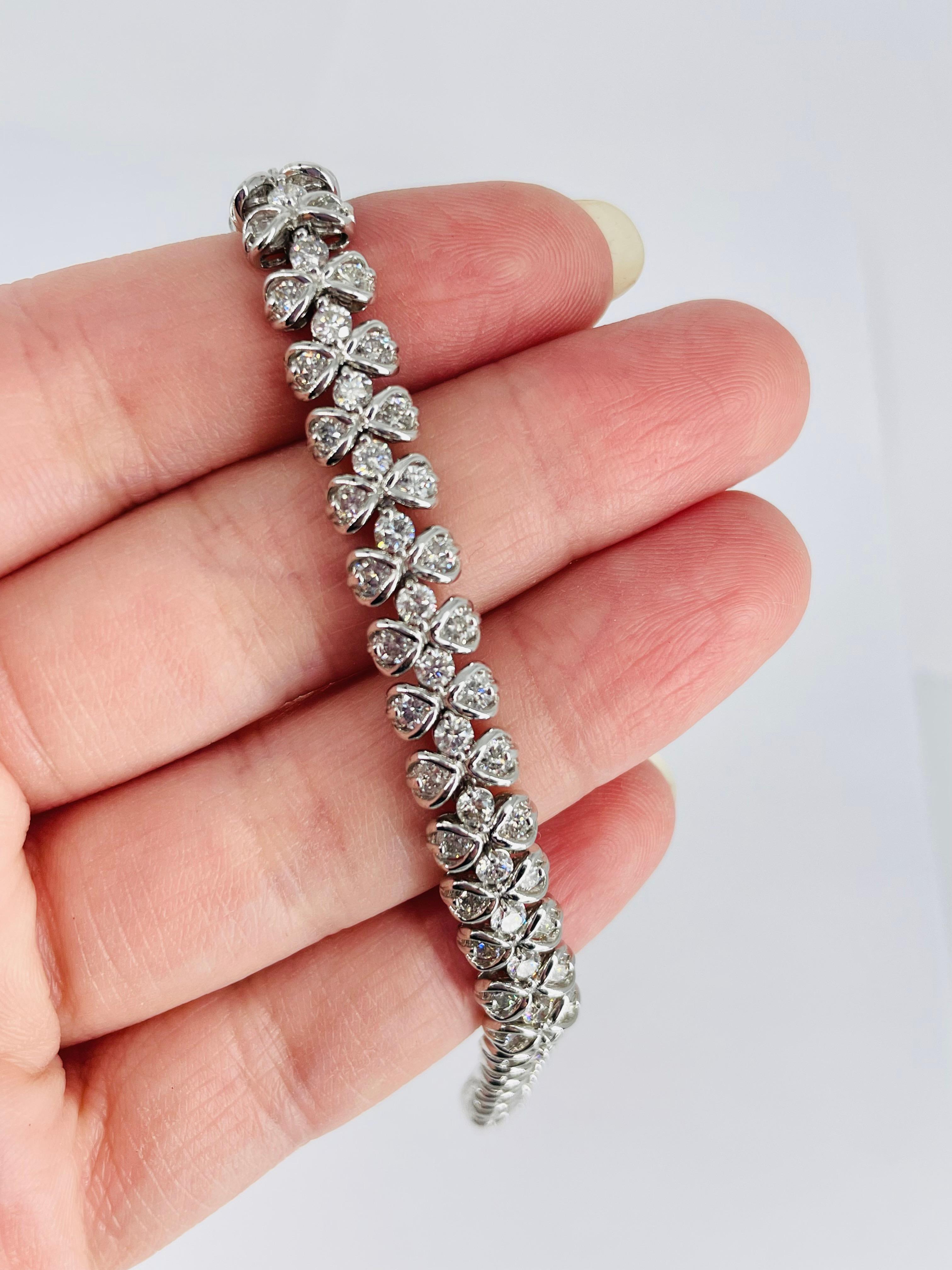 This sparkling diamond bracelet is a unique take on the classic tennis bracelet. Three rows of round diamonds create a soft scalloped shape.  The two outside rows of diamonds are set in a delicate half bezel which adds definition to the stones. The