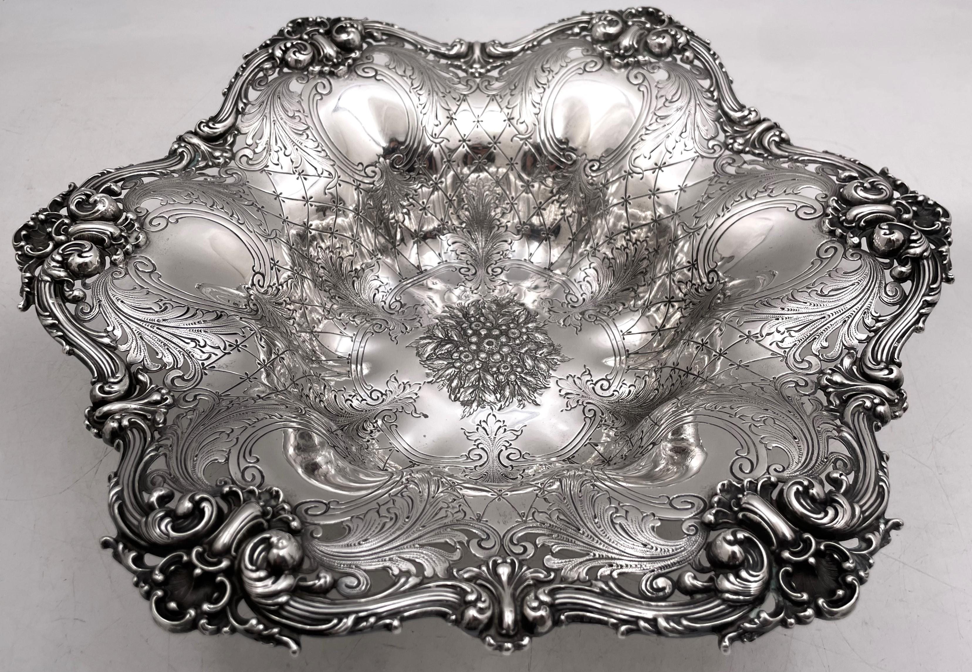 J. E. Caldwell & Co. sterling silver bowl in Art Nouveau style with a pierced rim adorned with curvilinear motifs and showcasing raised and engraved motifs across, from the early 20th century. It measures 12 1/2'' in diameter by 2 3/4'' in height,
