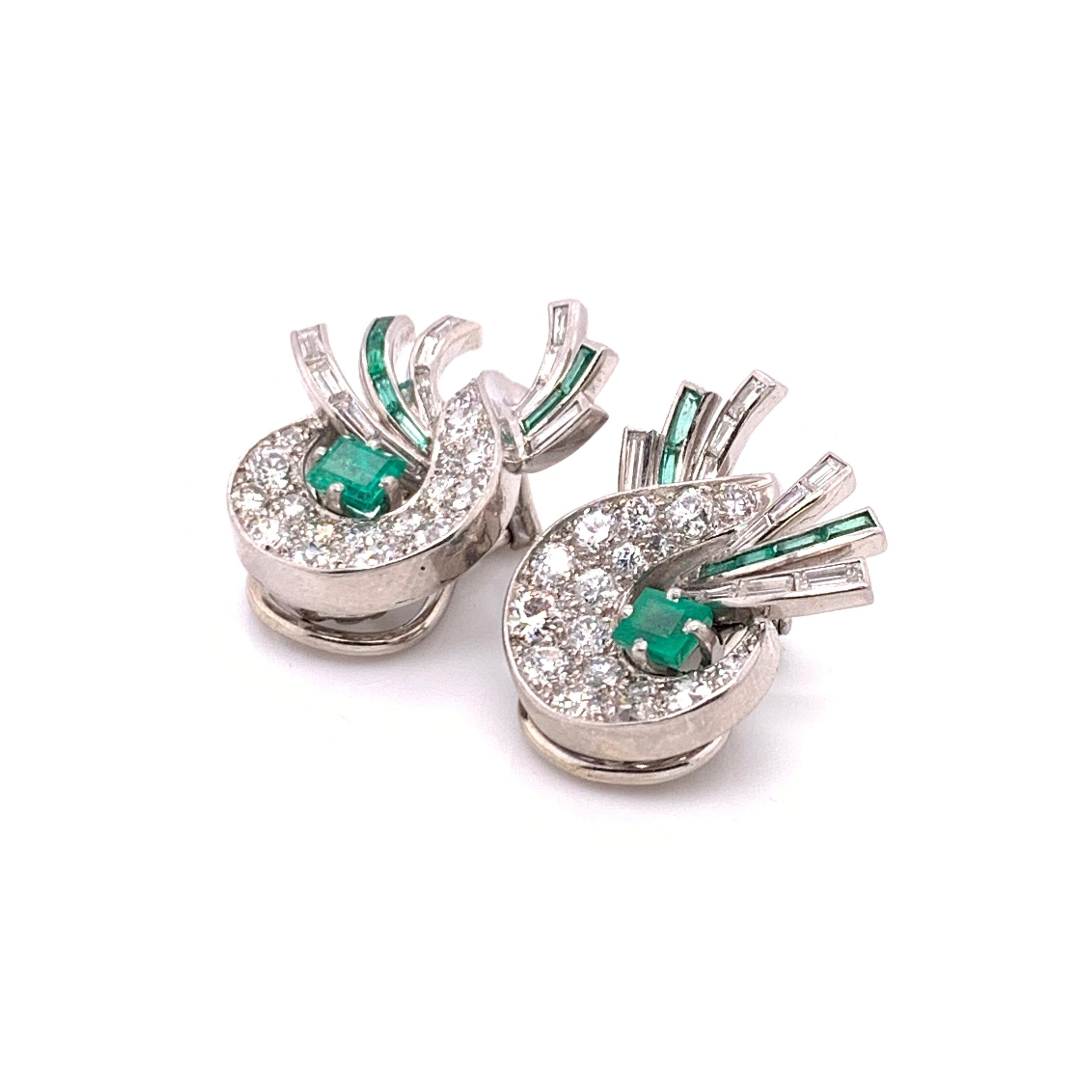A pair of J. E. Caldwell, vintage, emerald and diamond, clip-on, earrings, with pavé set, Edwardian brilliant-cut diamonds, in a stylised crescent, enclosing an emerald-cut emerald, with three, alternating ribbons of channel set baguette-cut