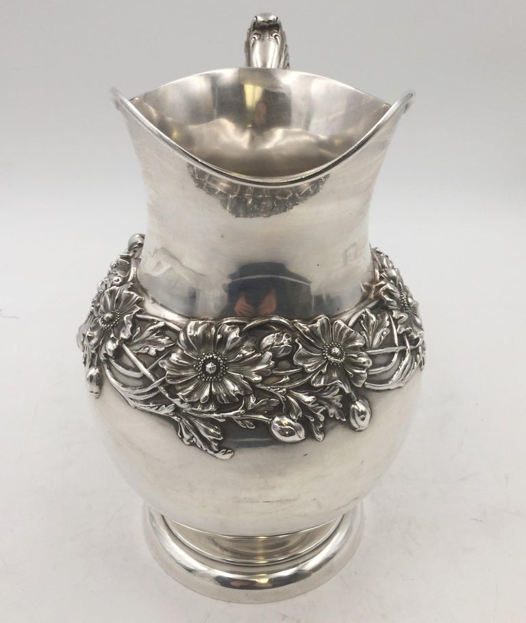 J. E. Caldwell sterling silver pitcher in exquisite Art Nouveau style with dimensional anemones around the body and an applied handle. It measures 9 1/4'' in height by 8 1/4'' from handle to spout by 4 1/2'' in width, weighs 23 ozt, and bears