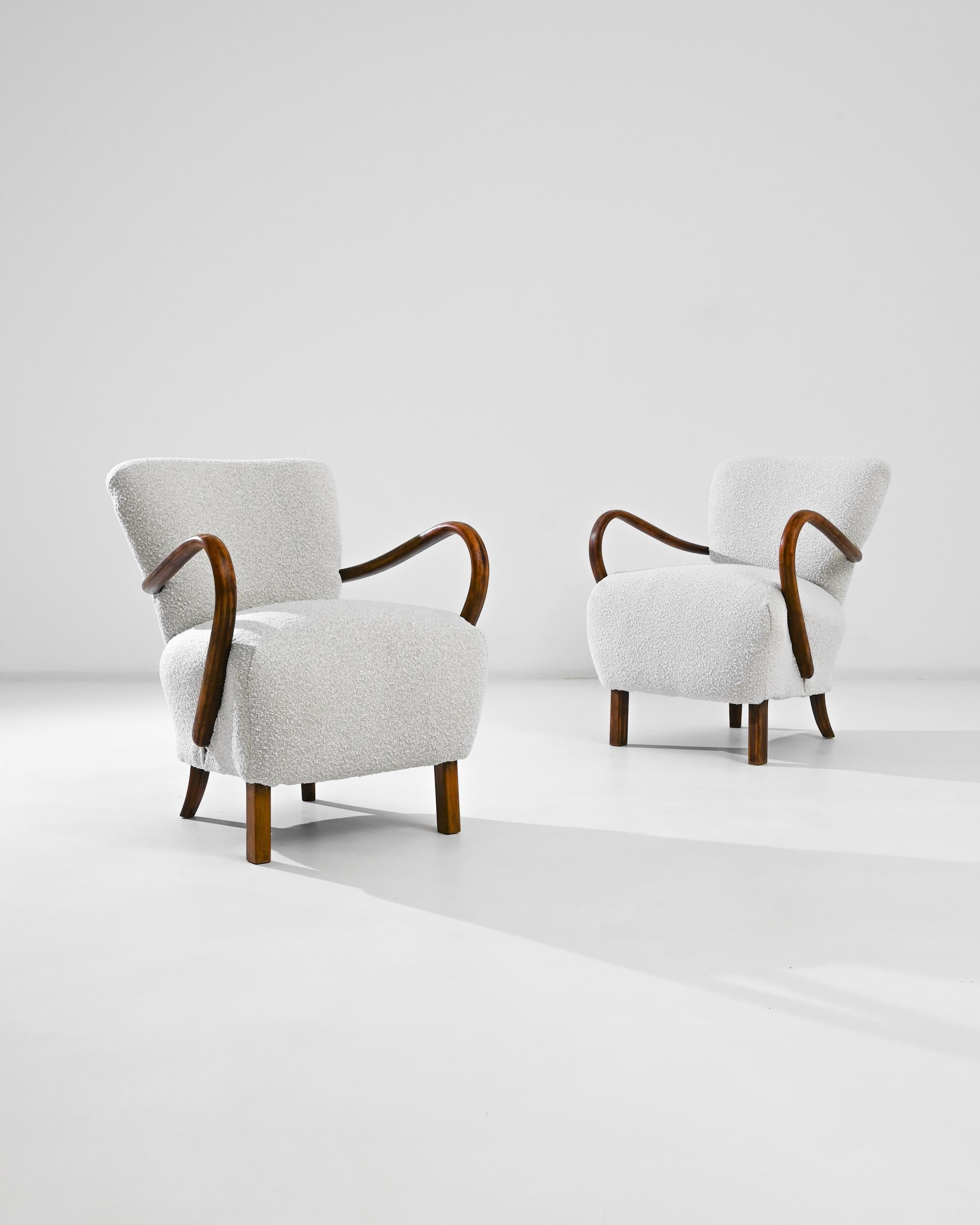 The dramatic curve of the bentwood armrests instantly distinguishes armchairs designed by J. Halabala, one of the most prominent industrial designers from Czechia. Manufactured circa 1930, these lounge armchairs flaunt a modernist anatomy