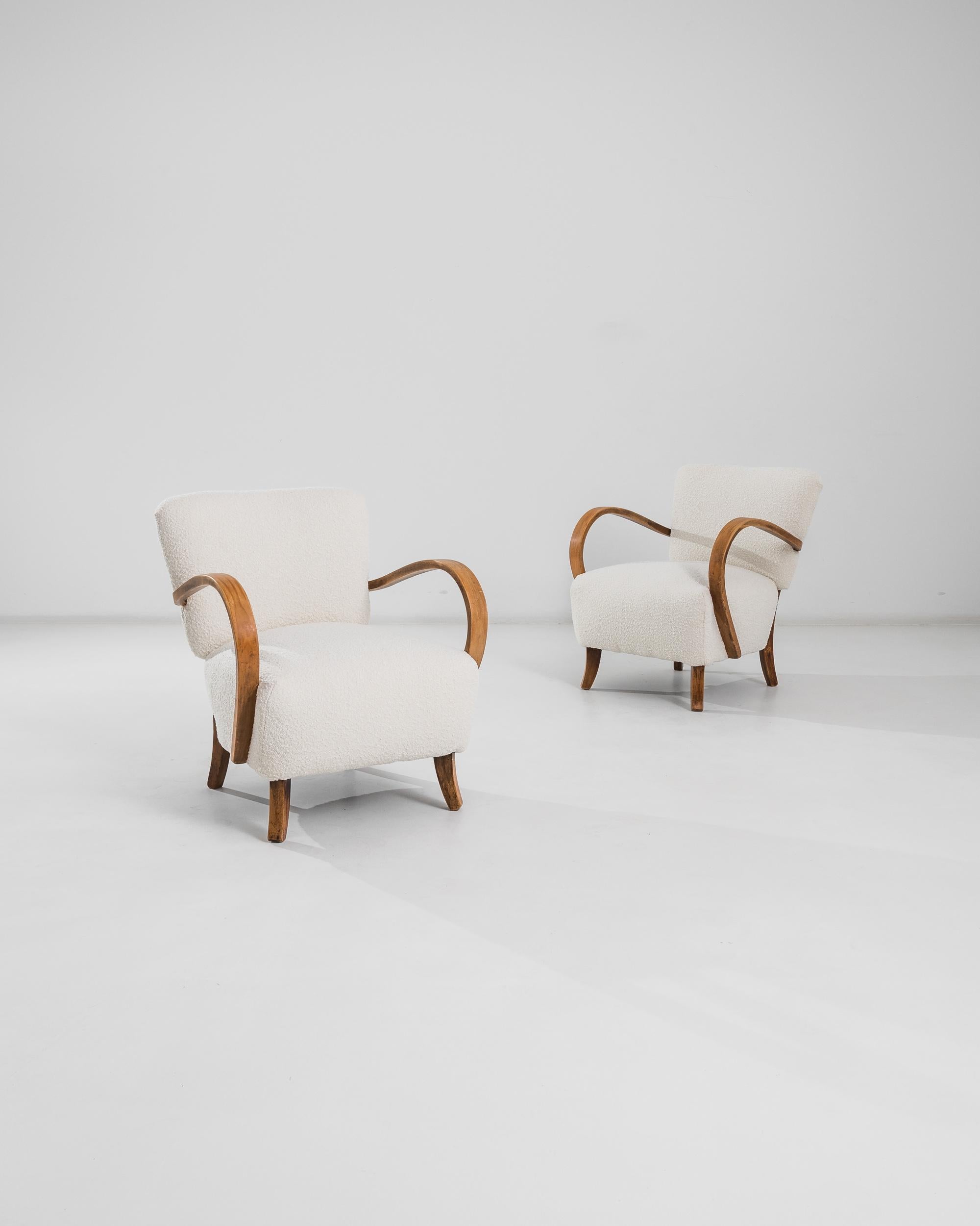 The dramatic curve of the bentwood armrests instantly distinguishes armchairs designed by J. Halabala, one of the most prominent industrial designers from Czechia. Manufactured circa 1930, these lounge armchairs flaunt a modernist anatomy