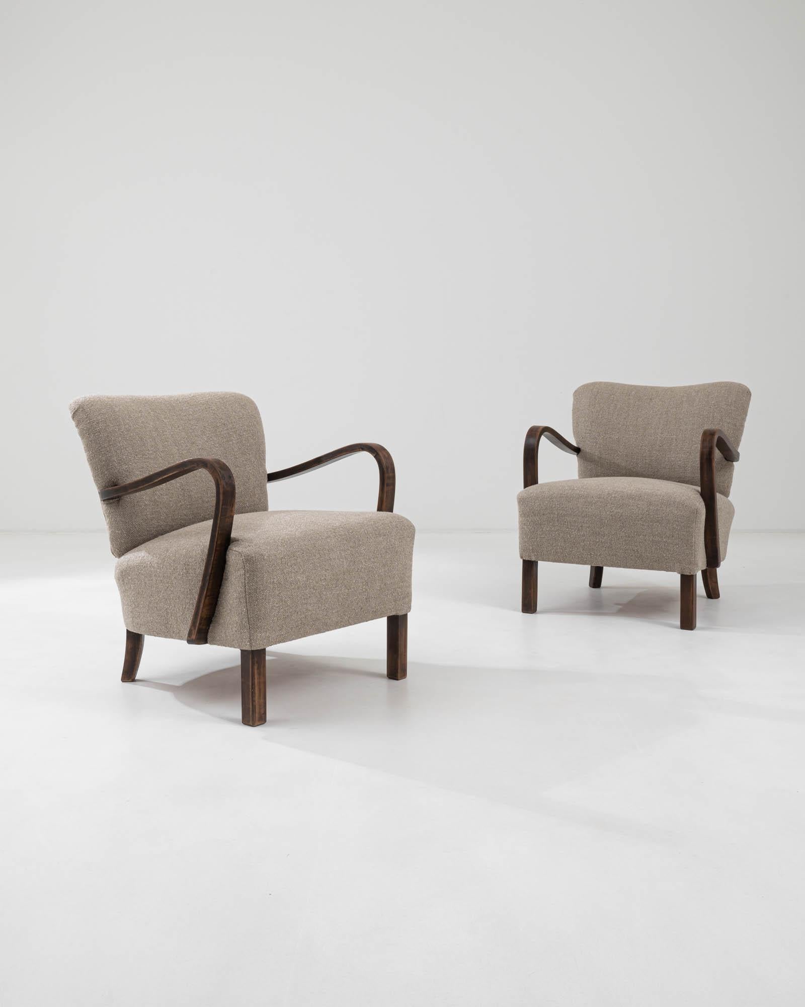This iconic design by J. Halabala is instantly distinguished by its characteristic bentwood armrests and playful shape. Manufactured circa 1930, these lounge armchairs flaunt a modernist anatomy constituted by dynamic geometry; sturdy square feet