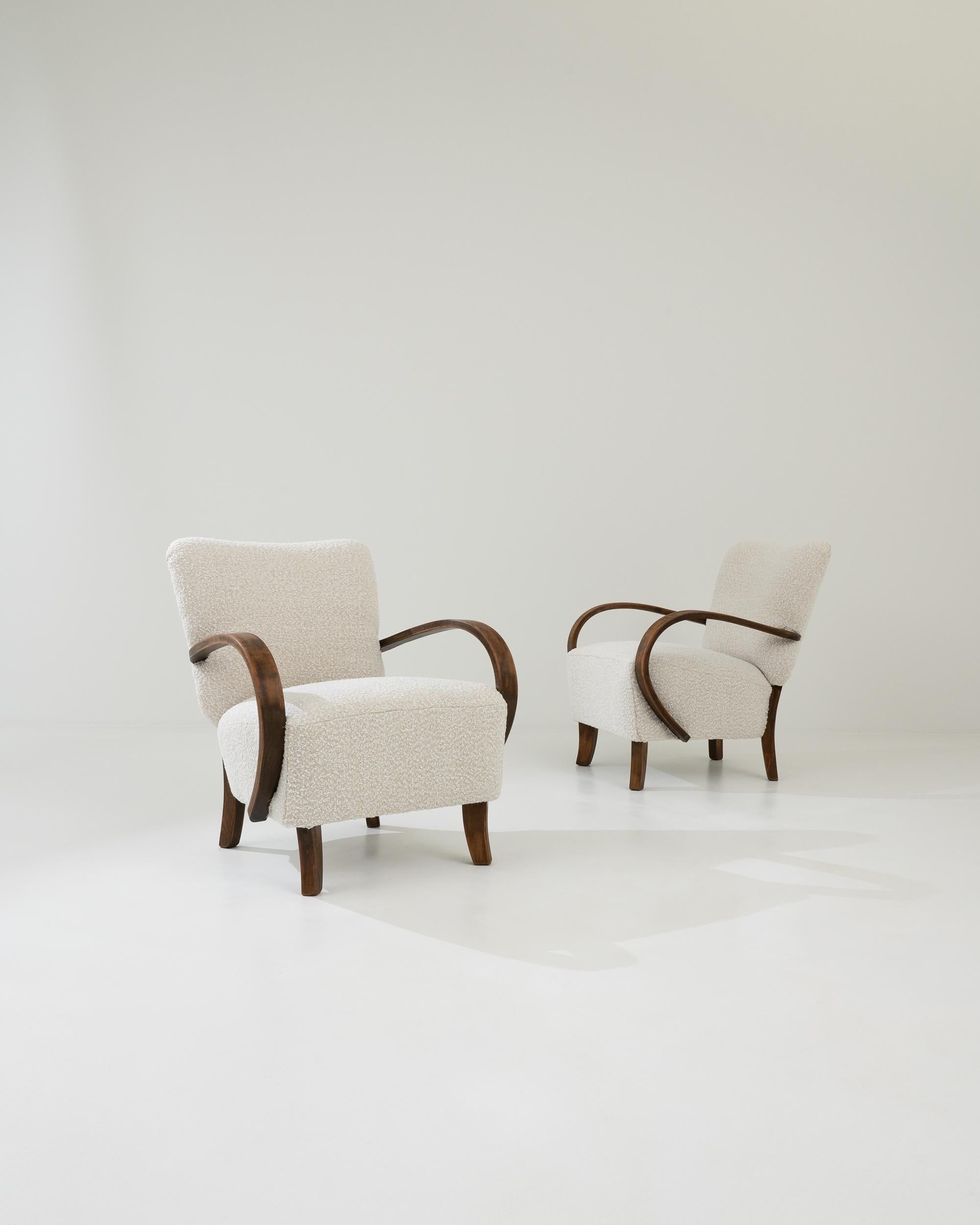 This iconic design by J. Halabala is instantly distinguished by its characteristic bentwood armrests and playful shape. Manufactured circa 1930, these lounge armchairs flaunt a modernist anatomy constituted by dynamic geometry; sturdy square feet