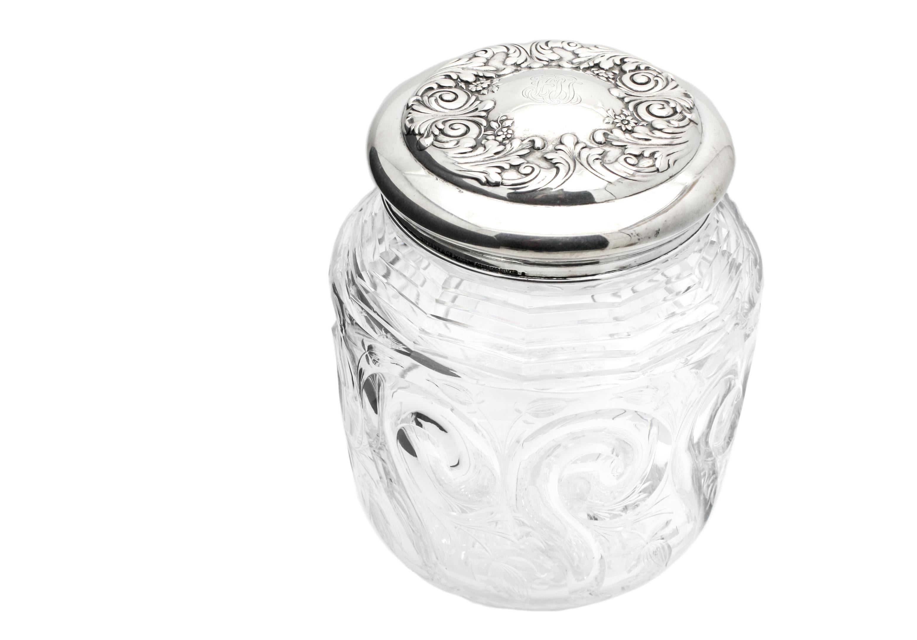 This is an exceptional and rare example of John Hoare's workmanship in the classic lidded biscuit barrel. The body is wheel cut with an Art Nouveau swirling tusk pattern accompanied by engraved flowers and an intricately cut base. It is further