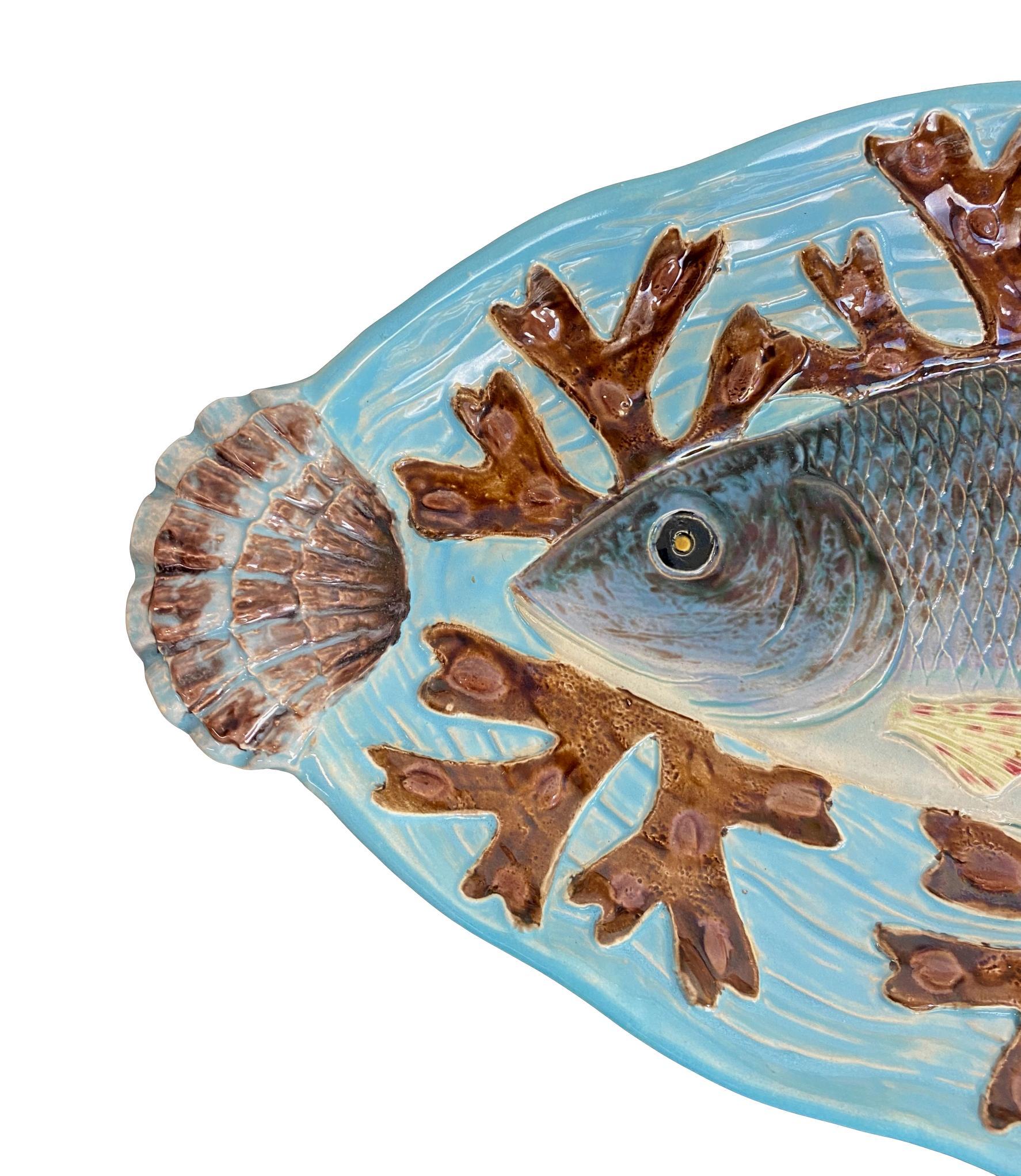 Joseph Holdcroft Majolica Trompe L'oeil salmon platter, naturalistically molded with a life-like salmon on a bed of red seaweed, on a relief molded basket-weave turquoise ground. Measures: 22-ins. wide.

For 30 years we have been among the world's