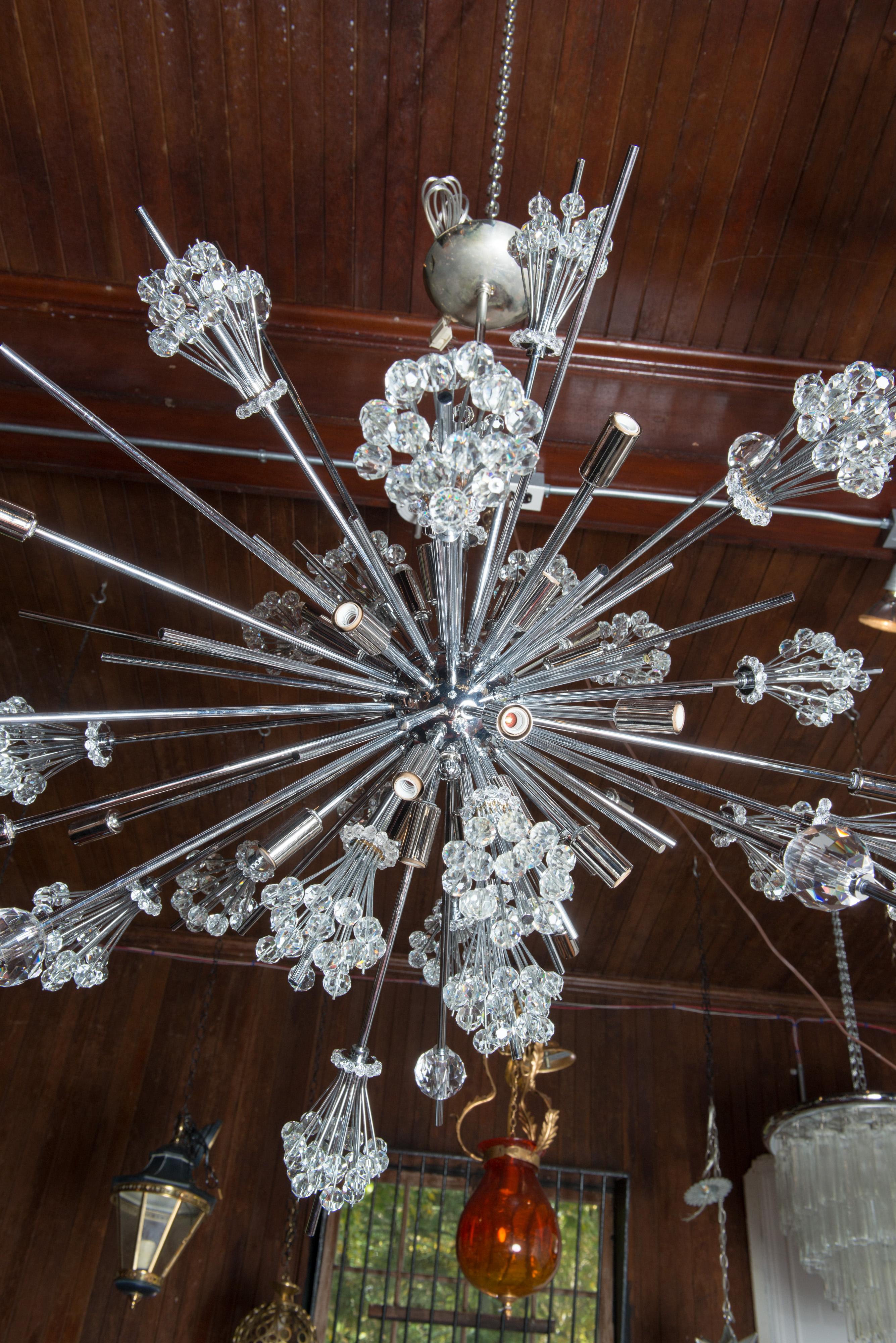 Metropolitan Opera starburst chandeliers were originally made by Hans Harald Rath of the Austrian company, J. & L. Lobmeyr in 1966. This starburst chandelier is made by Lobmeyr in chrome and cut crystal. The chandelier holds 30 bulbs.