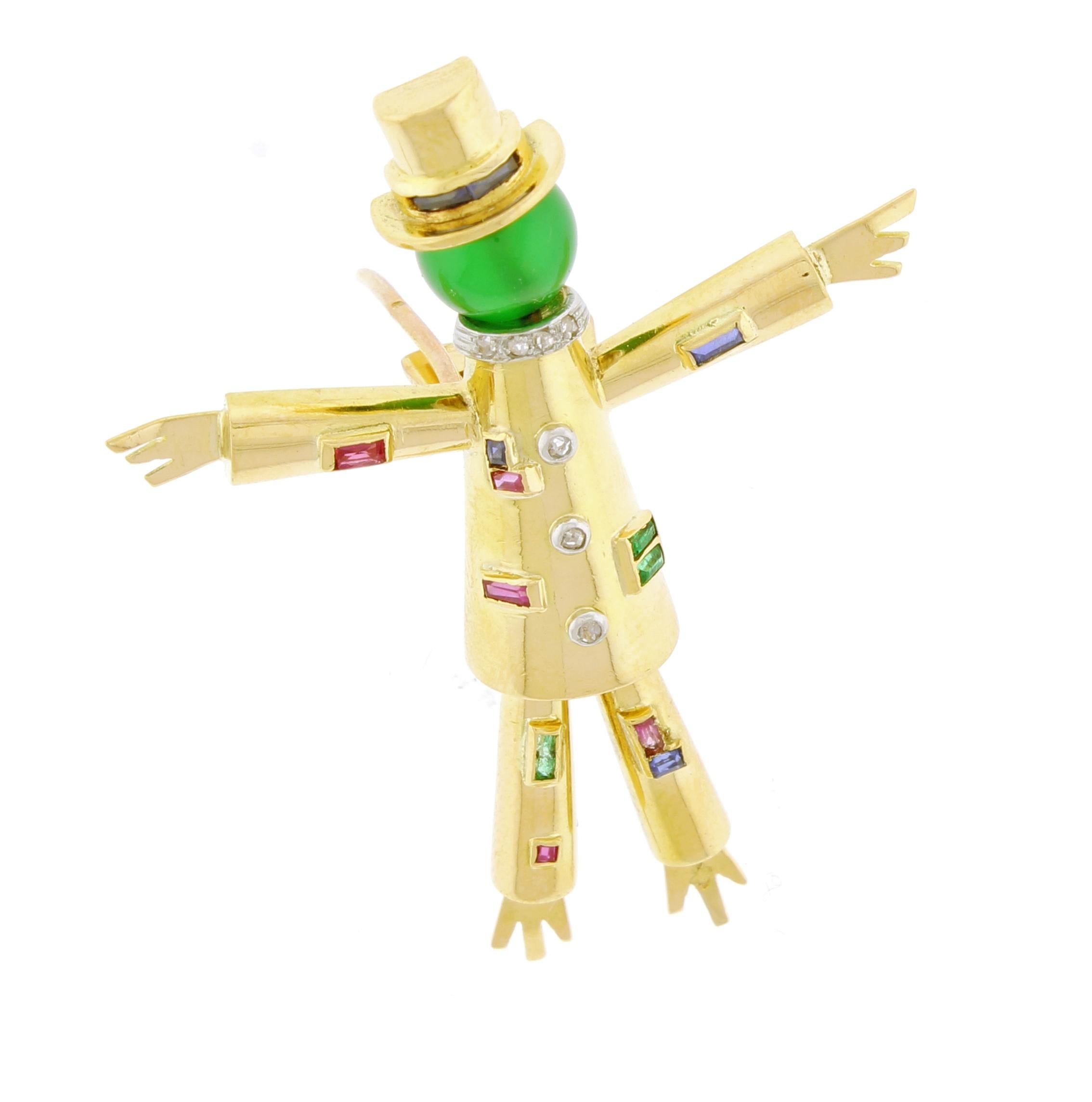 Jacques  Lacloche created the l'épouvantail (scarecrow)  clip brooch to commemorate the opening of his salon in Pairs. The registered design is crafted in 18 karat gold with rubies diamond sapphire emeralds and a green glass bead.  2 inches high