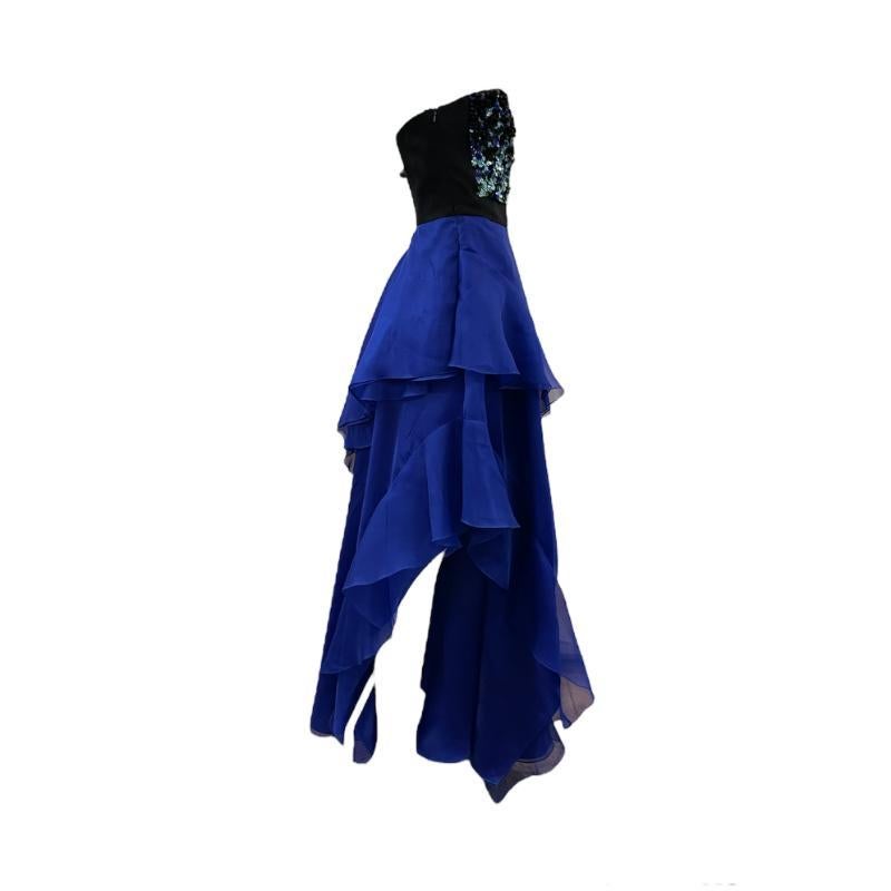 Contemporary gown from revered fashion house J Mendel. Super stunner of a gown in electric blue organza with heavily sequined strapless top. full skirt falls in tiers with one side fully exposing upper leg. A sexy secret. Black silk corset top with