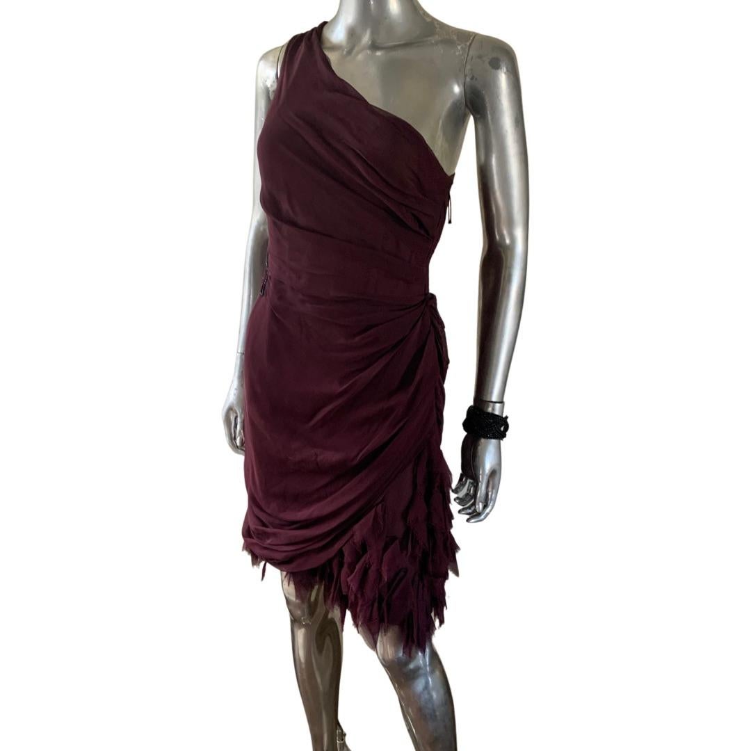 An Uber chic cocktail dress design by J. Mendel Paris. The dress is all silk in the most lovely color of a deep port wine. The short dress has so many highlights going for it. From the one shoulder draped silk chiffon, to the torn pieces of silk
