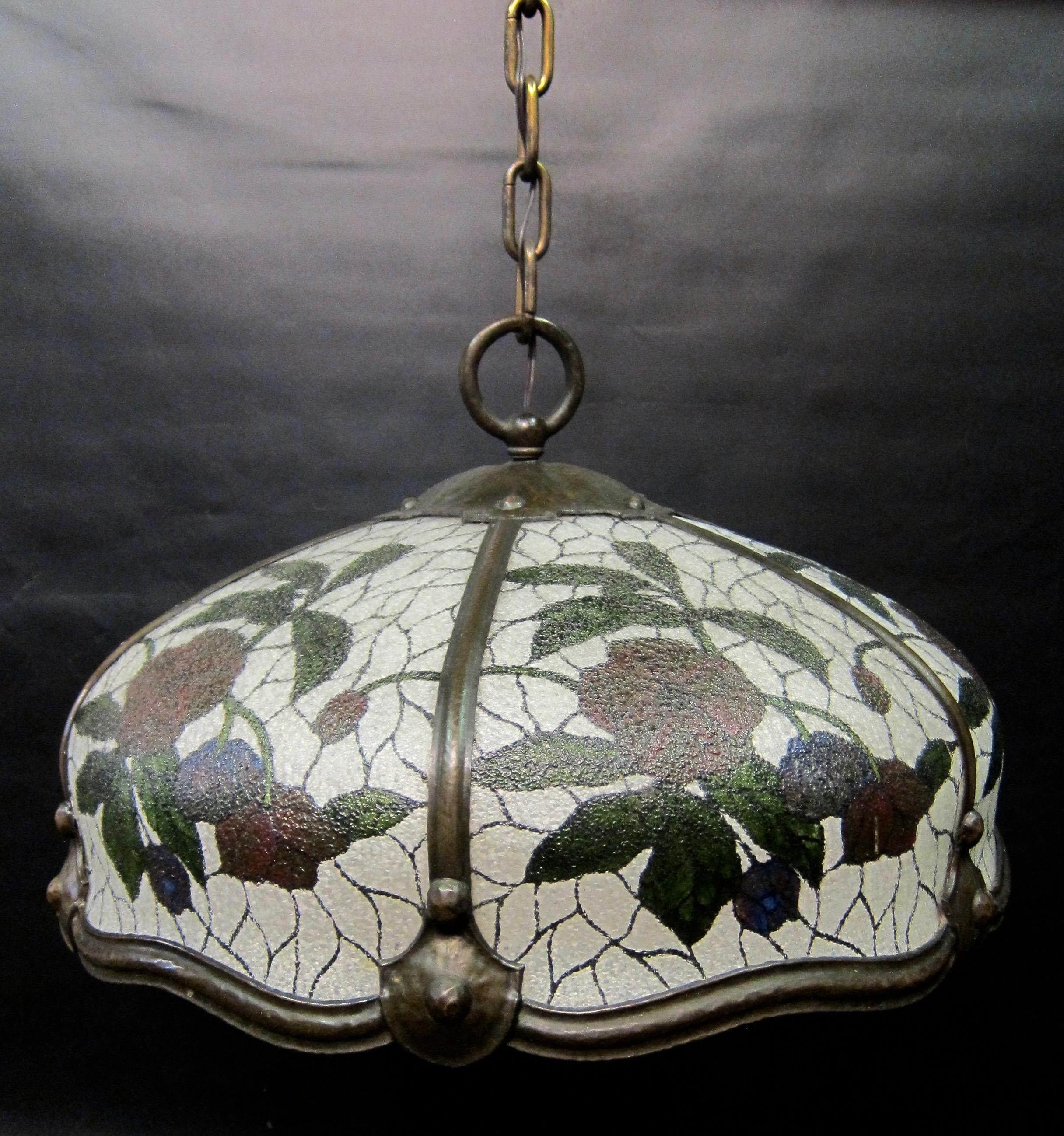A vintage early 1900s Arts & Crafts ceiling fixture designed with reverse painted glass panels within a patinated hand-hammered bronze framework. Each hand painted panel is detailed with flowers on a textured curved glass that compliments the