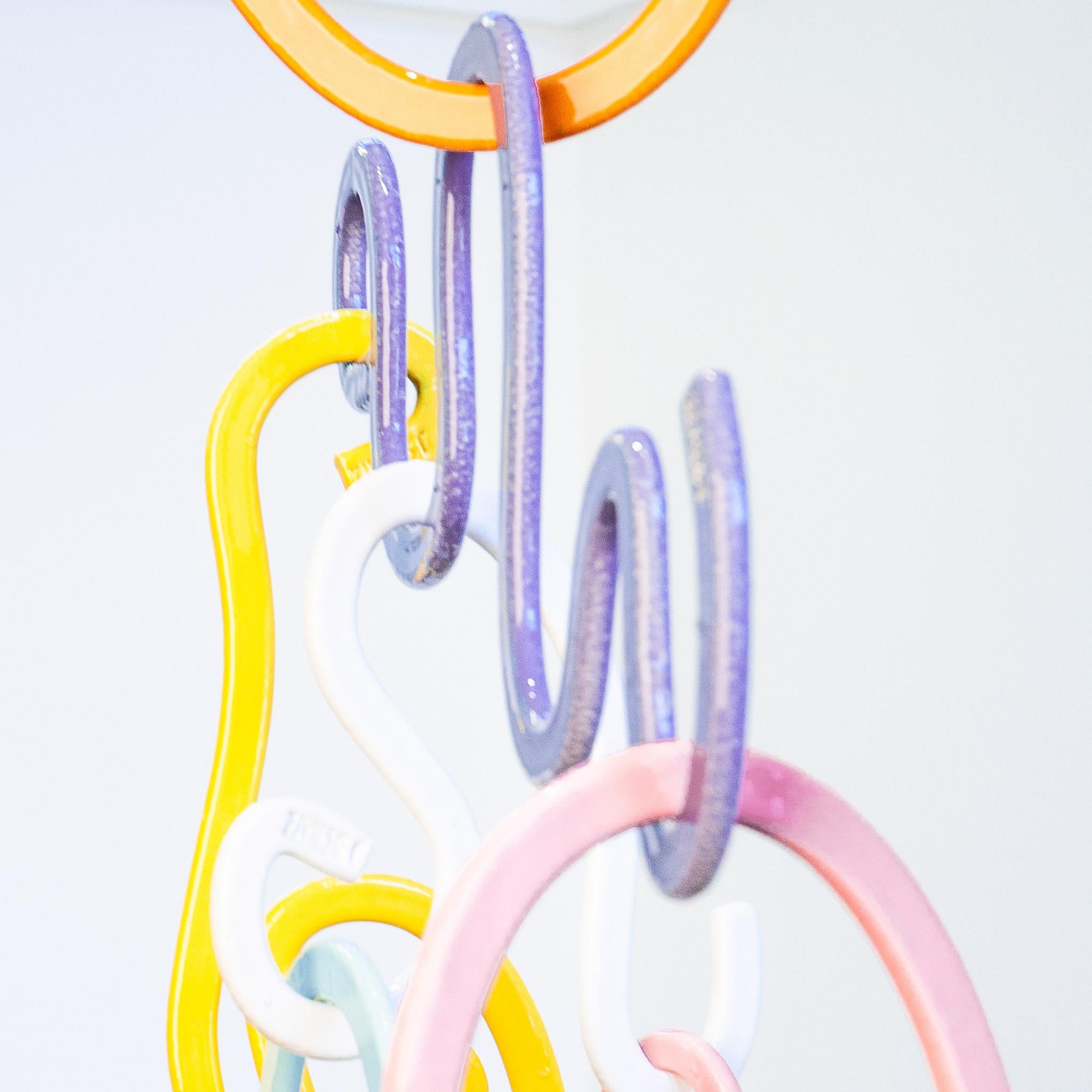 A product and process of chance, the J Schatz Doodle Mobile is no mere accent piece. The mobile's 14 stoneware clay extrusions envelop you in color and shape. Each piece is glazed on both sides in one of eight colors and stamped 