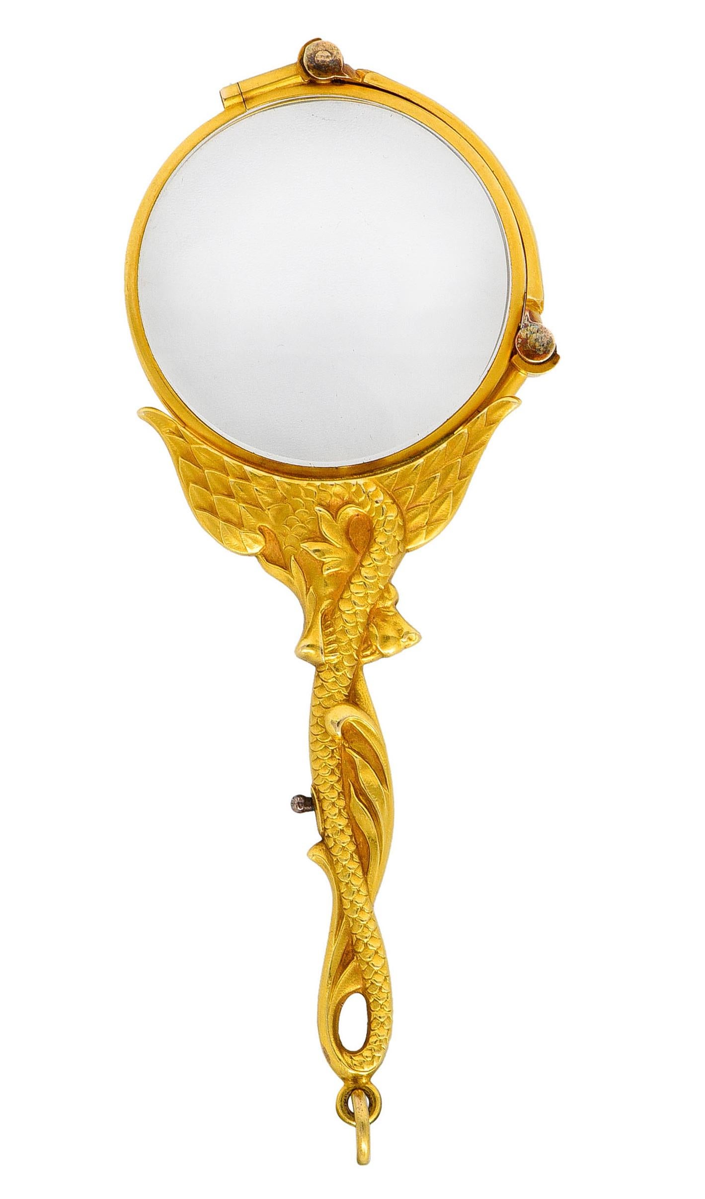 Designed as lorgnette glasses with collapsable dual lenses that release via lever mechanism

Handle is ornately rendered as a whiplashed serpent dragon with detailed wings and scales

Terminates as a jump ring bale

Bridge of glasses is stamped 14KT