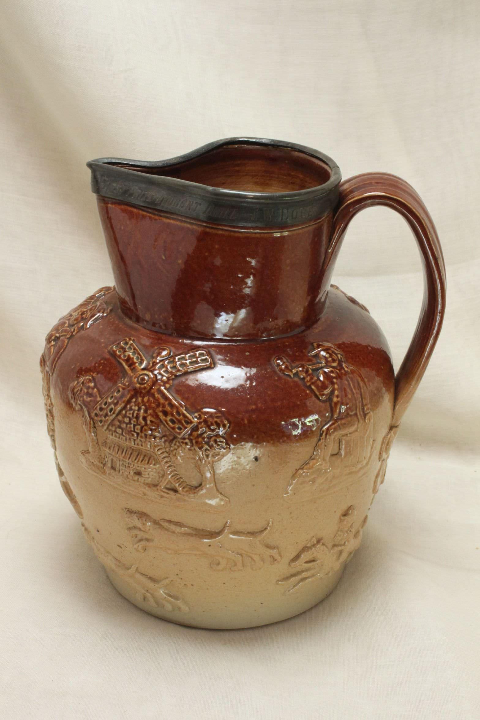 This salt glazed J Stiff Harvest ware jug was awarded to J W Dore, a member of the Chiswick Volunteer Fire Brigade in 1881. The inscription on the pewter mount reads 