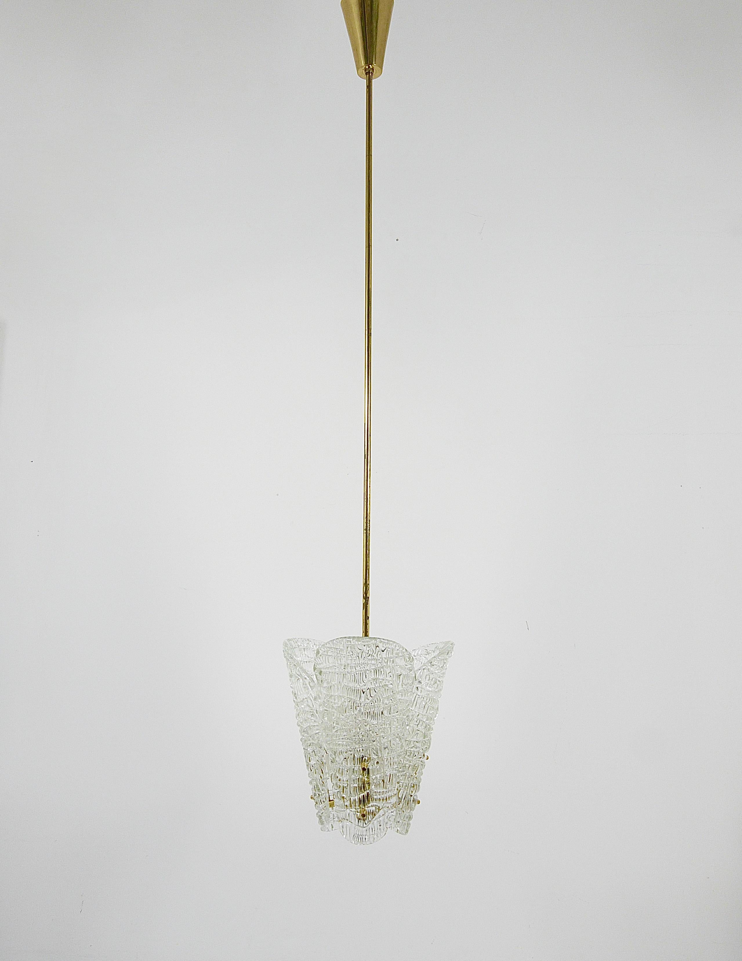 Wir präsentieren einen zierlichen Messing-Kronleuchter von J.T. Kalmar aus Wien, Österreich, hergestellt in den 1950er Jahren. Dieses schöne Stück besteht aus drei eleganten, löffelförmigen Lampenschirmen aus strukturiertem Glas, die an polierten