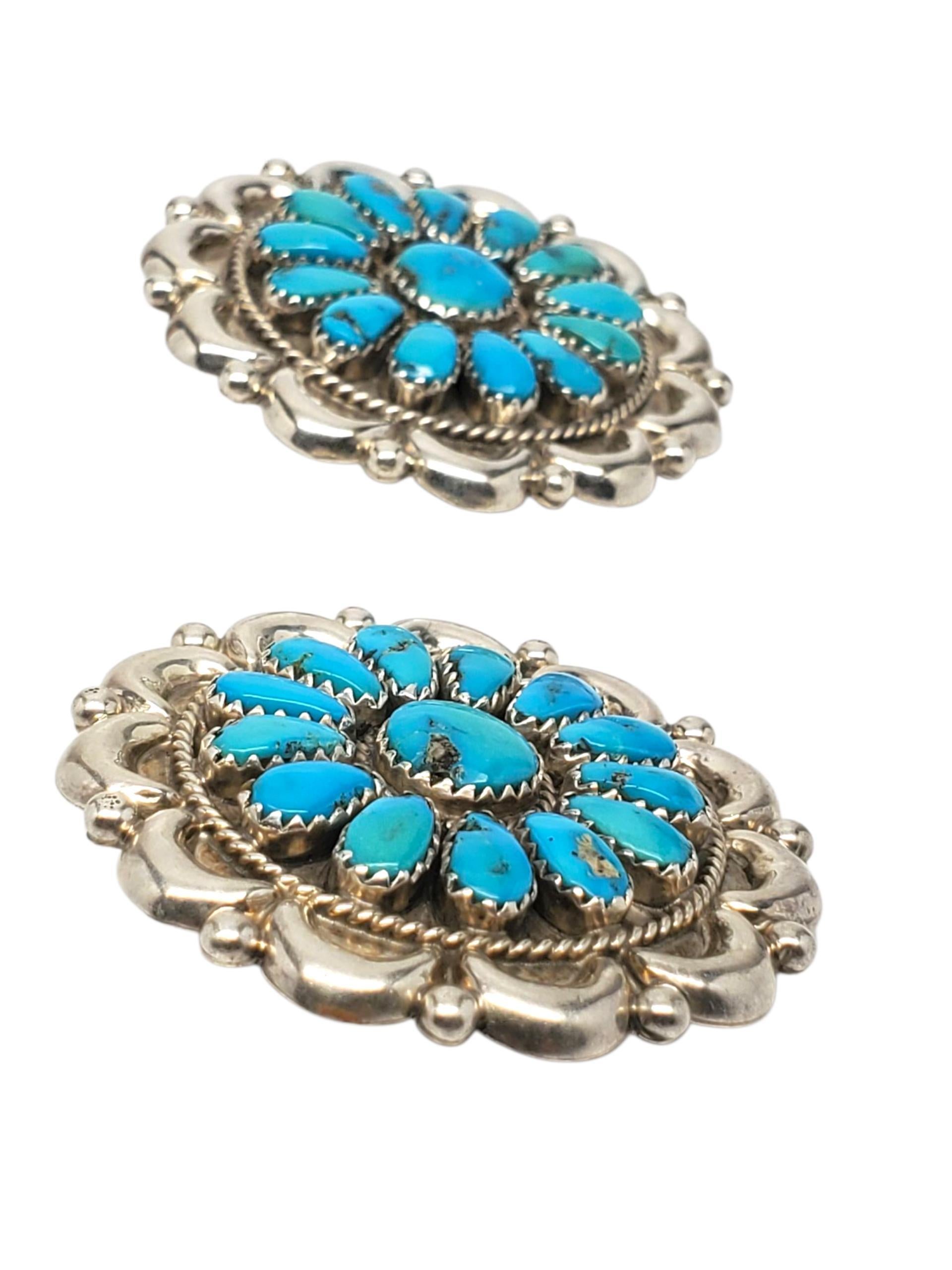 J. W. Sterling Silber Native American Türkis Concho Ohrringe -

Diese kühnen Concho-Ohrringe mit Türkis-Cabochons in einem strahlenden Sunburst-Muster sind handgefertigt in Sterlingsilber mit Push-Back-Verschlüssen, signiert J. W.

Größe: 43,2 mm x