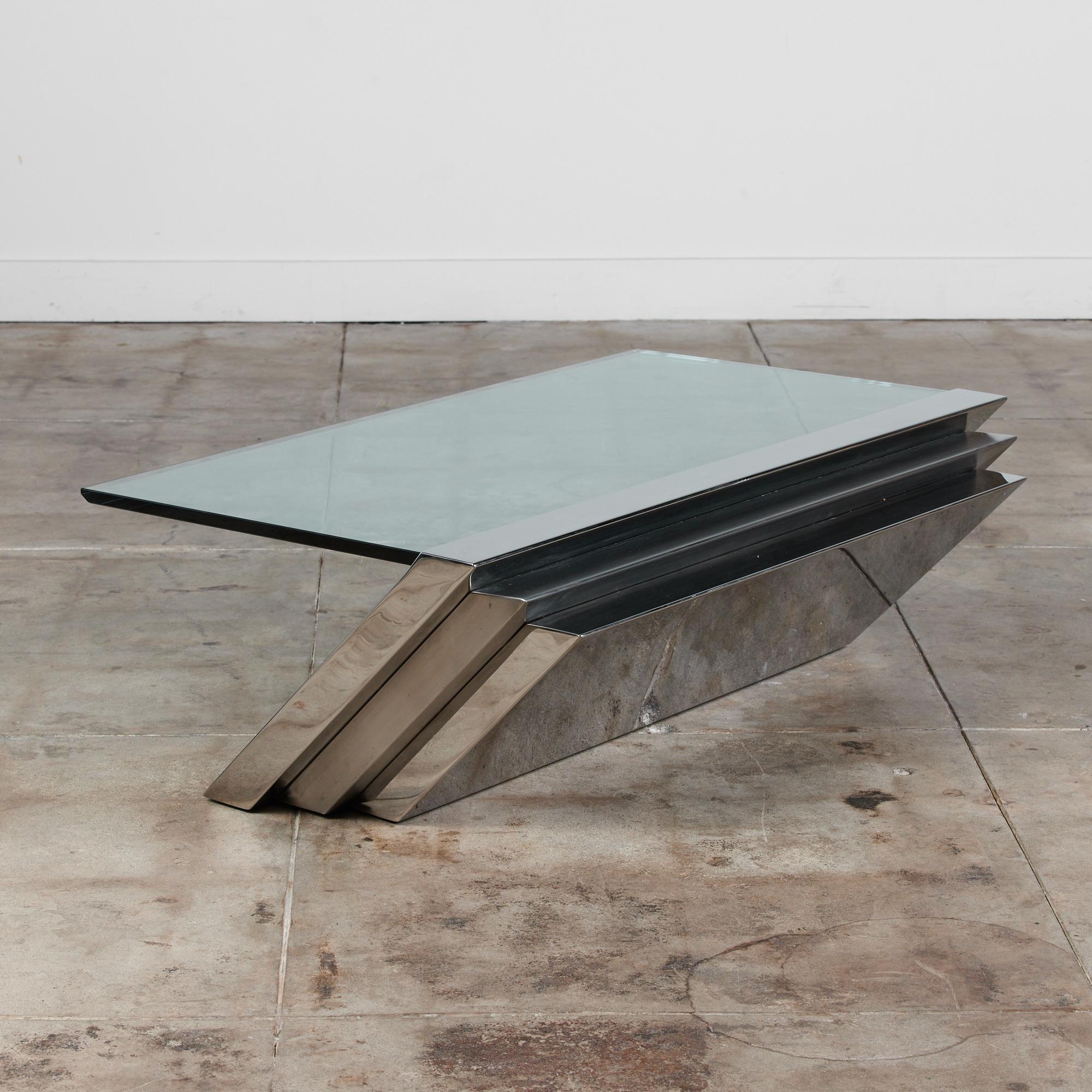 An angled long coffee table designed by J. Wade Beam for Brueton of New York. The company pioneered the use of stainless steel in home furnishings, and this example is typical of Beam's sharp, gravity-defying designs. A steeply angled stack of