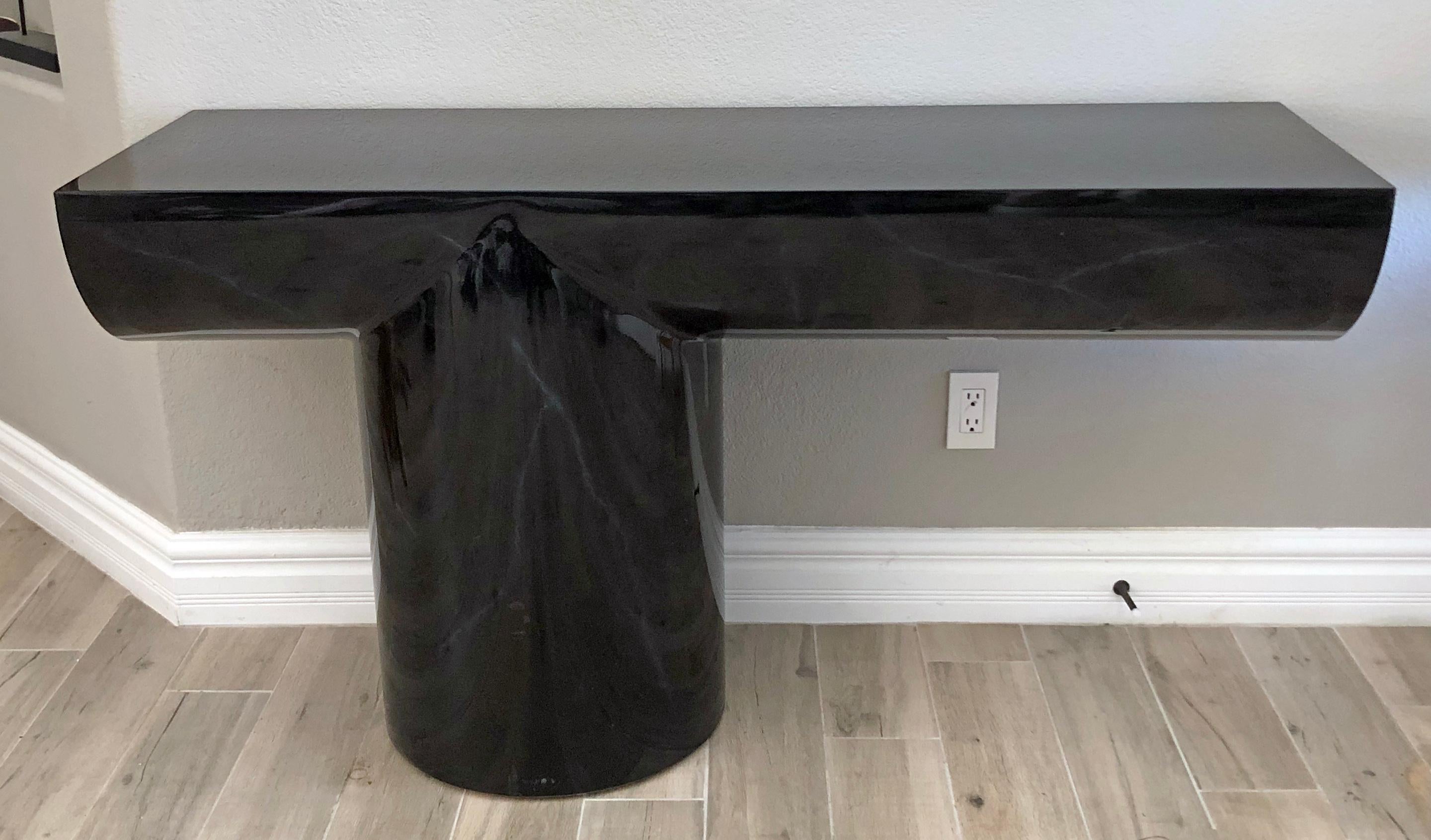 This piece is absolutely stunning! designed in the 1970s for Breuton Intl, this cantilevered modern console table is an onyx black with a very light tone-on tone marbled look. The piece is lacquered and is in great condition with minor wear