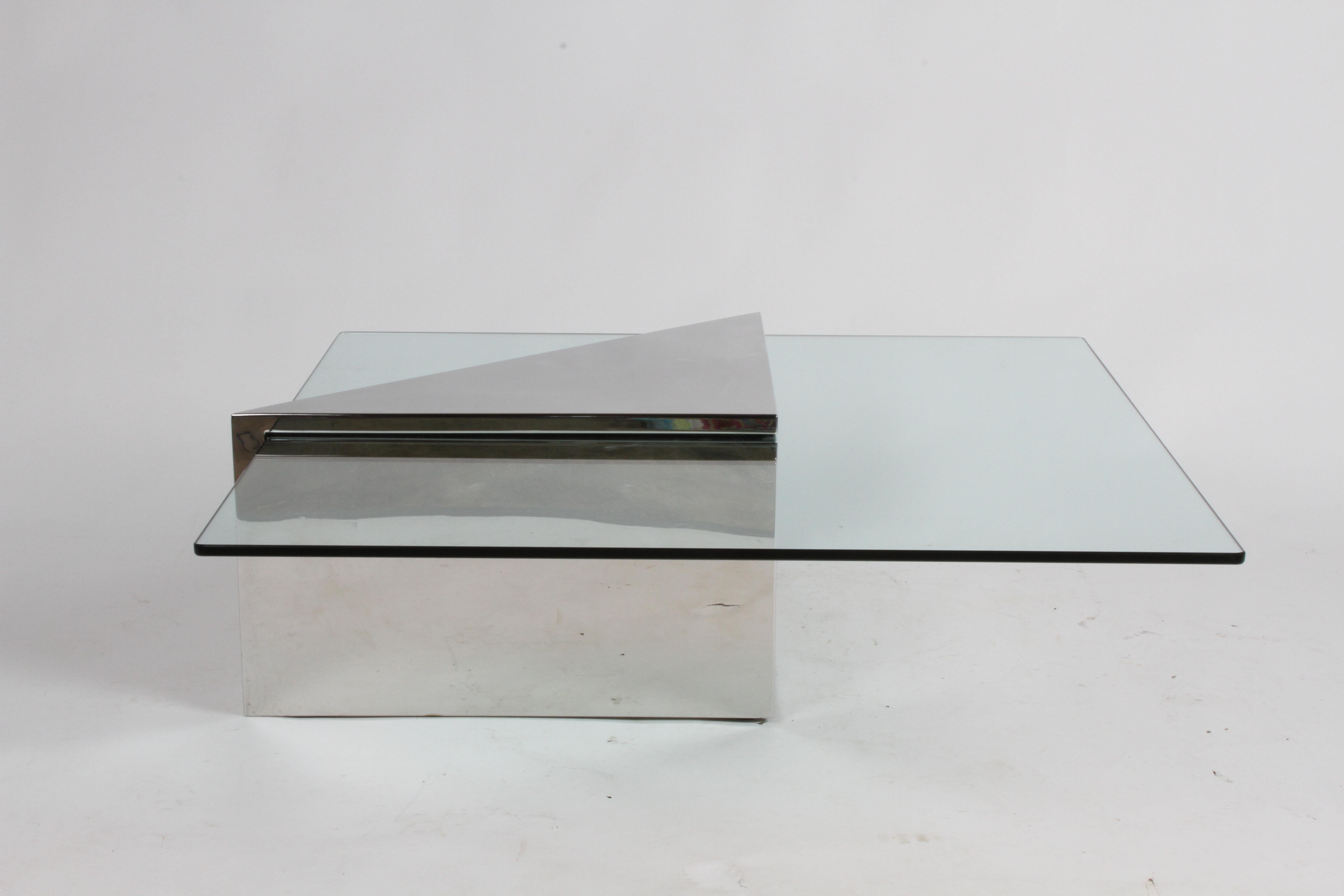 Triform coffee table designed by J. Wade Beam for Brueton, circa 1980s having a polished stainless monolithic triangular base with square glass top. Top of triangular base does show some surface scratches, since its stainless it can be polished out.