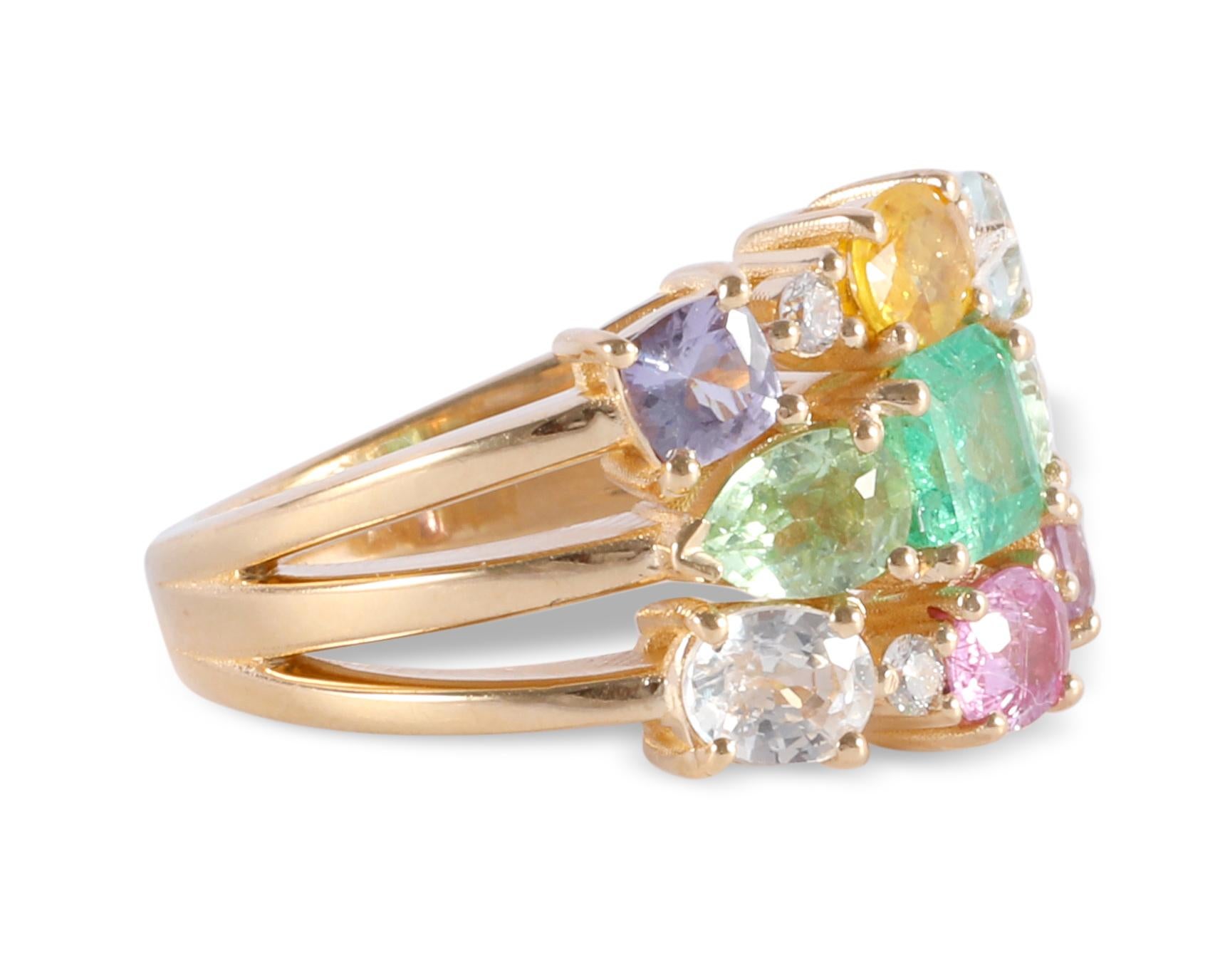 Brightly colored sapphires and a natural light green emerald make up this three row ring in 14 karat yellow gold.  With 0.08 carats of G-VS round faceted diamonds. Contact us for a custom ring in your desired color scheme. 

