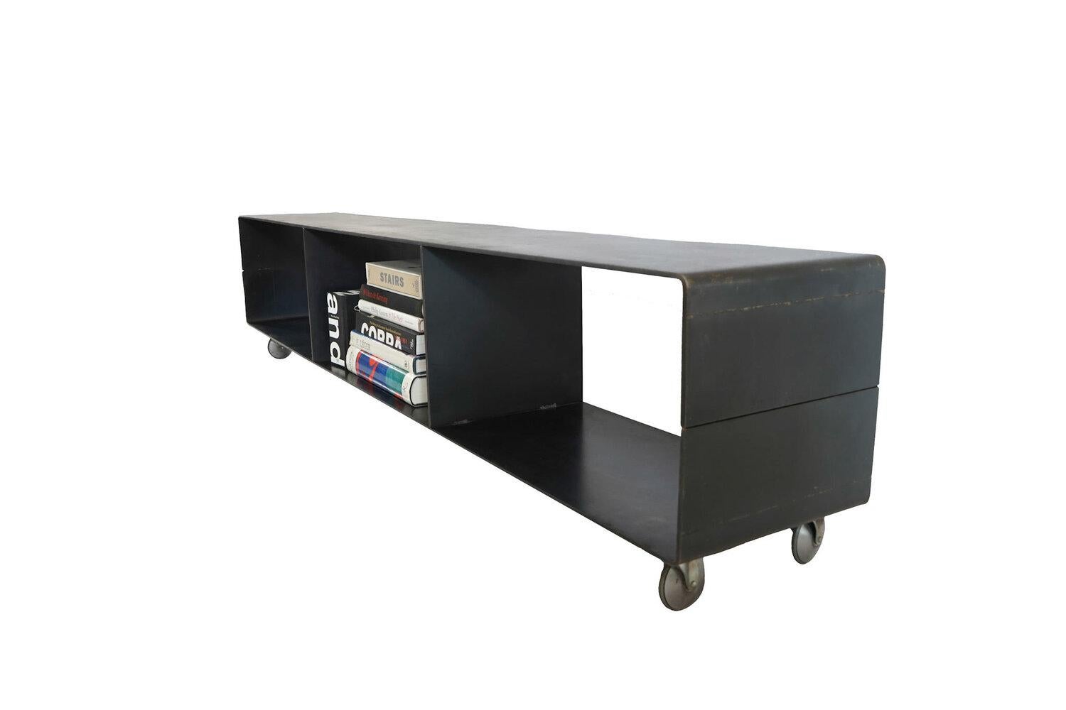 - Designed and handmade by Female Founded Design Firm 
- Blackened, hot rolled steel bookcase on castor wheels
- Handmade in the USA, made with USA Steel
- Made to order
- Measures: L 71” x W 18.25” x H 10”
- Hot Rolled J Series

The Hot