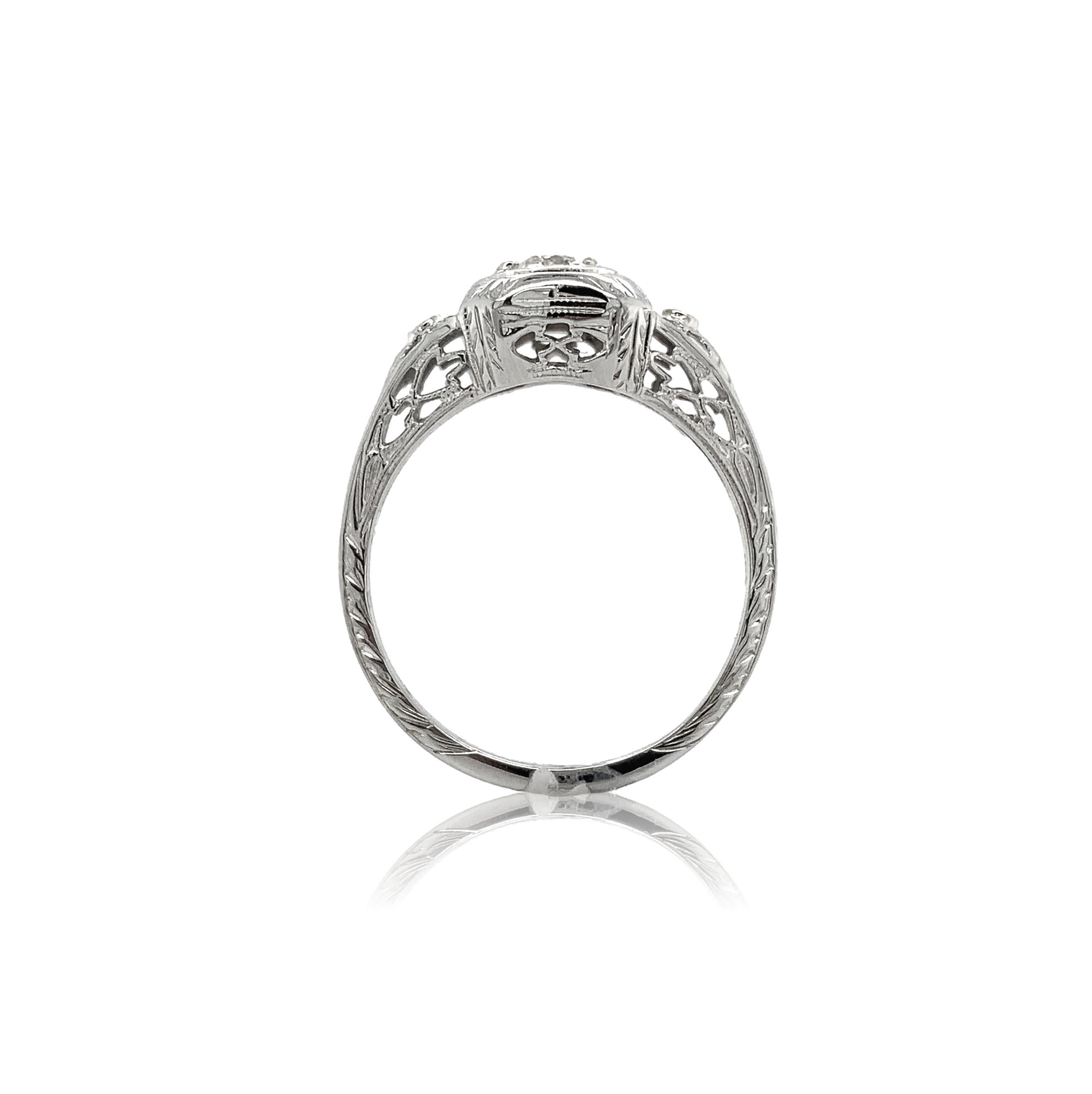 Filigraner Ring aus 18 Karat Weißgold mit einem antiken Diamanten im europäischen Schliff mit einem Gewicht von 0,23 Karat. Der Diamant hat die Reinheit SI1 und die Farbe H-I und misst etwa 3,8 mm. Es gibt 8 neue Perlenzacken. Es gibt 2 kleine runde