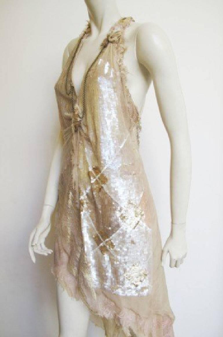 Jaagh Couture long asymmetric dress composed of a set of overlapping fabrics that intertwine. We play on materials, pastel colors and reliefs. Beige, off-white and white sequins yoke, beige tulle, gold lace and flesh.
It is sleeveless, V neck