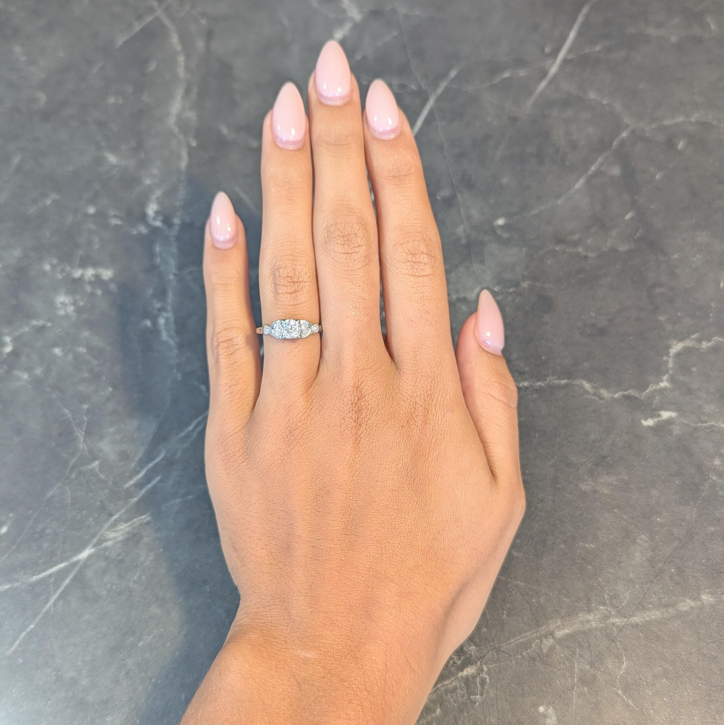 Engagement ring centers an old mine cut diamond weighing approximately 0.55 carat total
Set with triple split prongs in a stylized square form head - L color with SI2 clarity
Flanked by grooved crescent motif shoulders with bead set single cut