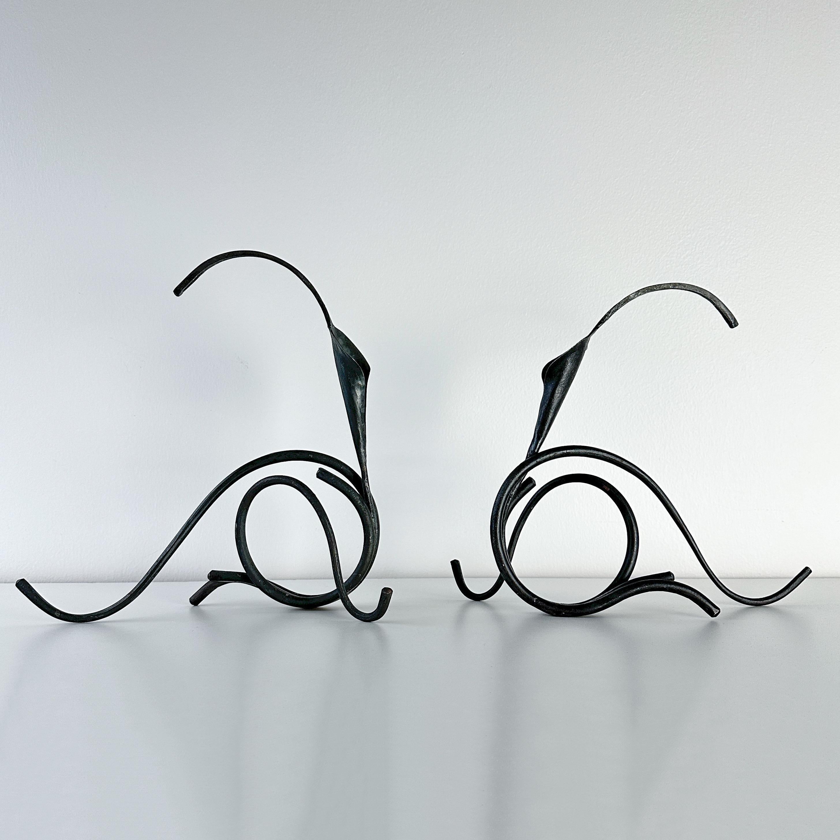 Vintage pair circa 1980s of sculptural hand forged iron candle holders in the shape of calla lillies by 20th century brutalist artist Jack Brubaker. Each sculpture piece holds a taper and is signed J. Brubaker. Dimensions listed are for each piece.