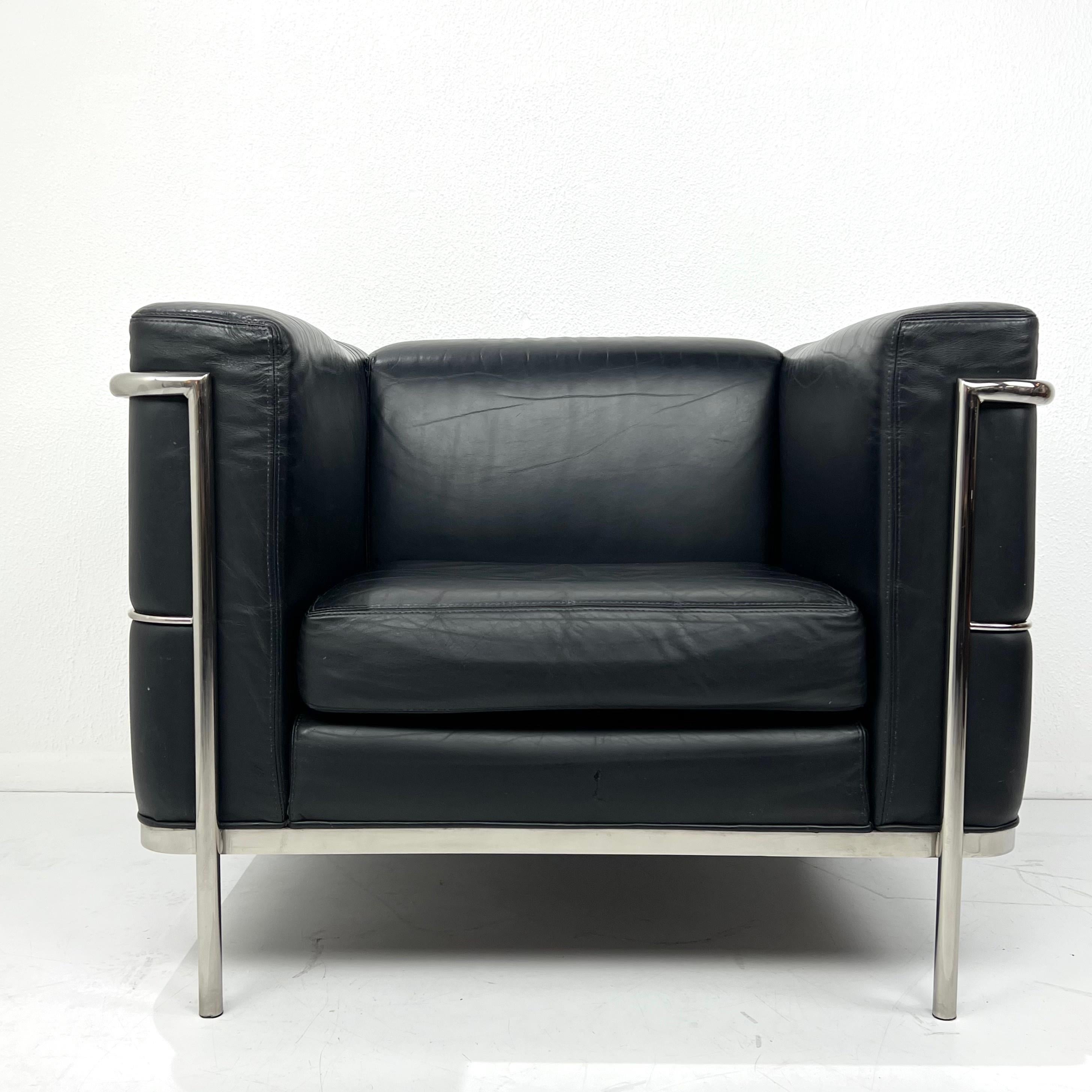 Handsome 20/123 cube club chair by Jack Cartwright after Le Corbusier’s LC2 chair. Features exposed tubular polished steel frame with black leather upholstery. Good condition with some wear/scratching consistent with age and use. Circa 2010. 