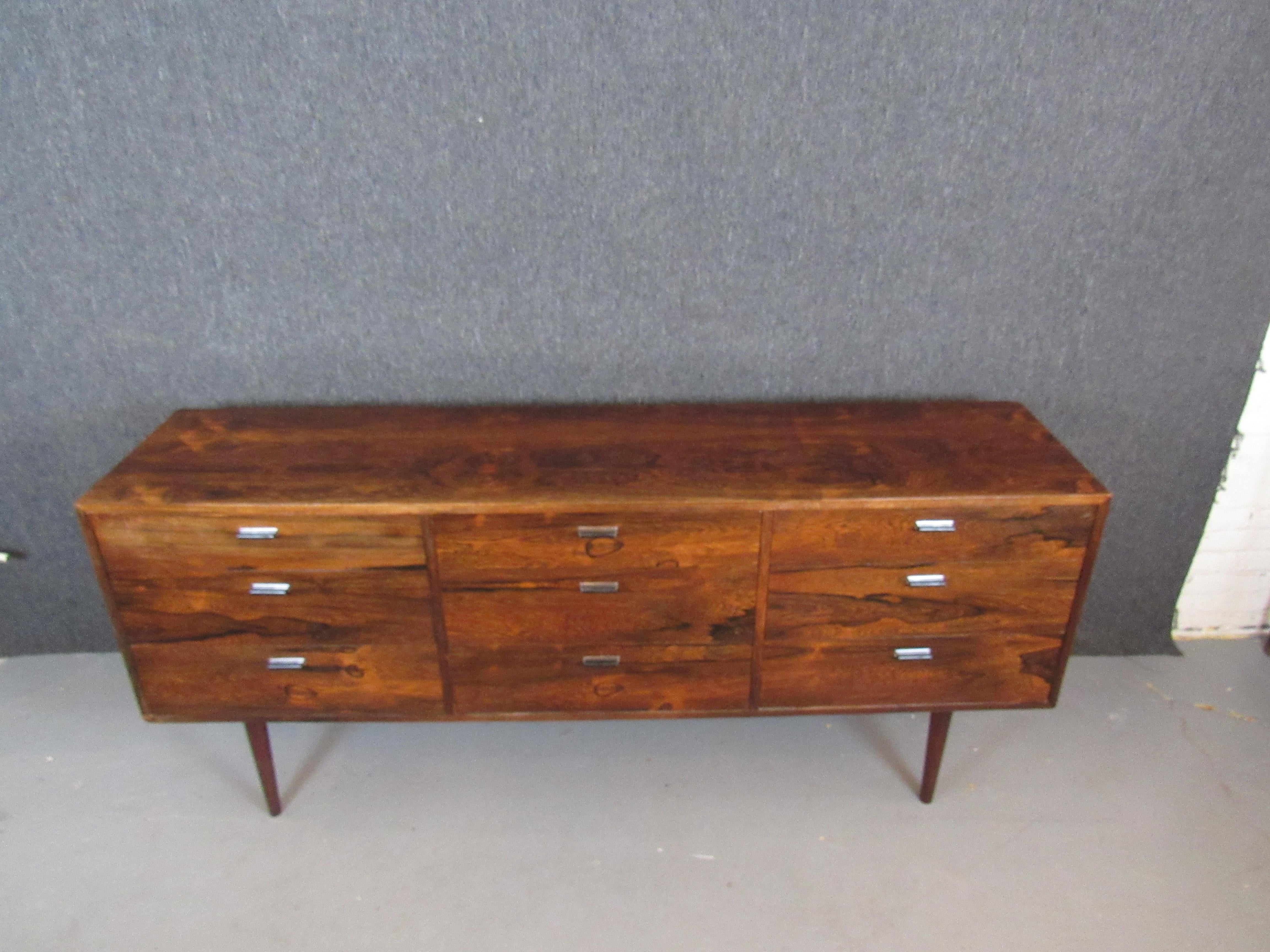 Exceptional mid-century rosewood dresser from American designer master Jack Cartwright for Founders Furniture. Nine ample drawers offer nearly limitless storage options, whether in the home or office. A truly jaw-dropping rosewood front blurs the