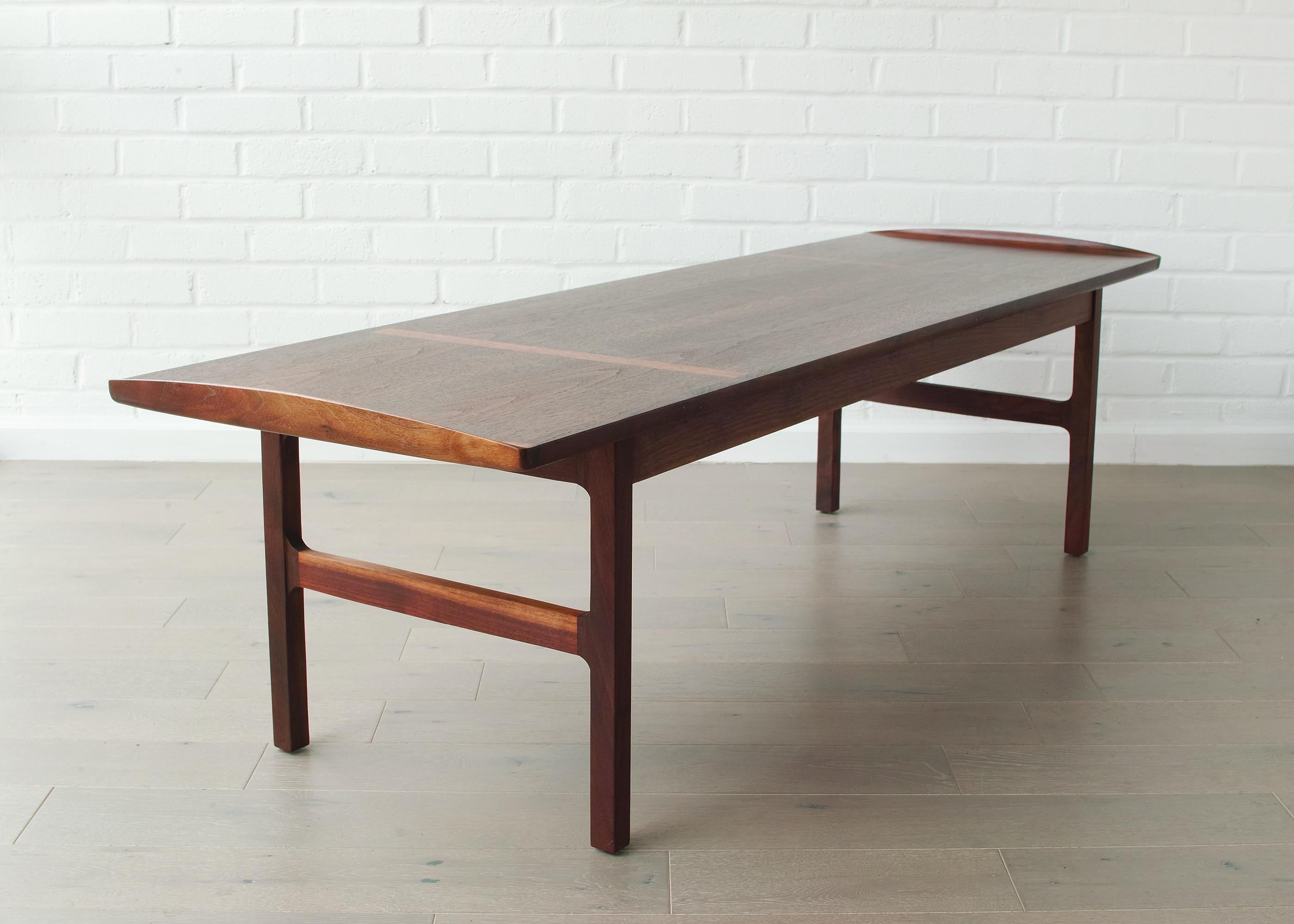 Nous vous proposons cette table basse en noyer du milieu du siècle, modèle #50111, conçue par Jack Cartwright et fabriquée dans les années 1960. Il se compose d'une base en noyer massif sur laquelle repose un plateau en placage de noyer assorti aux