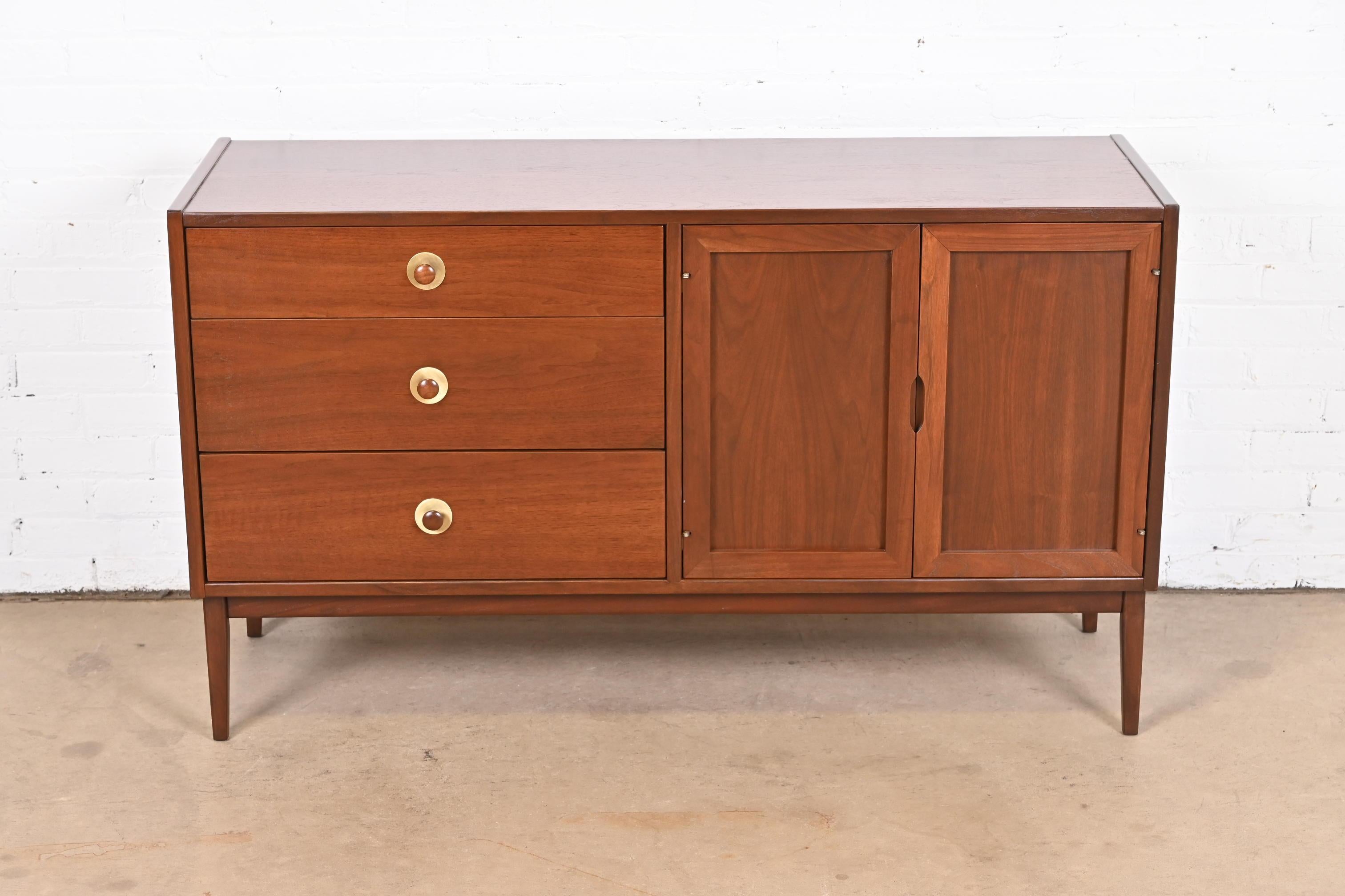 An exceptional Mid-Century Modern sideboard or credenza

By Jack Cartwright for Founders

USA, 1960s

Gorgeous walnut, with brass and walnut hardware and caned interior doors. Interior cabinet has a single adjustable shelf.

Measures: 52