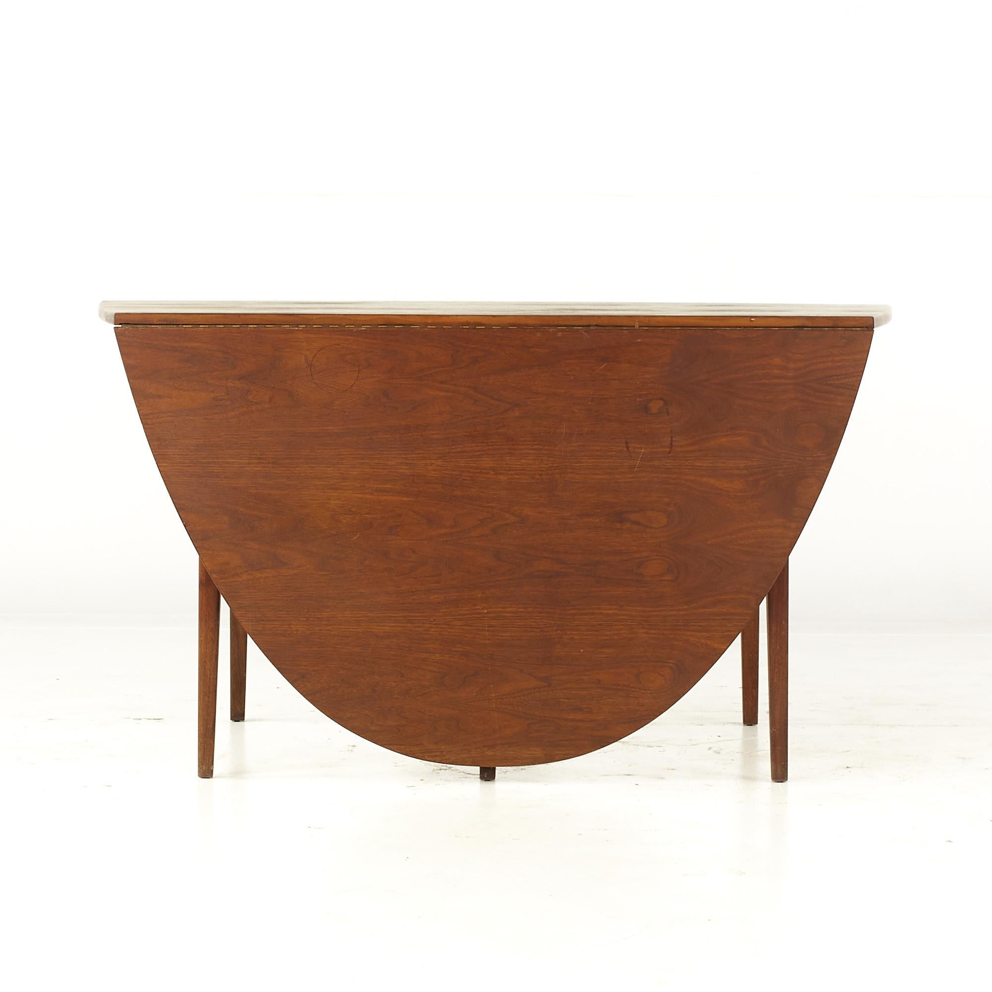 Jack Cartwright for Founders mid century walnut drop leaf dining table

This table measures: 27.25 wide x 54.25 deep x 29 high, with a chair clearance of 24.75 inches.
This table's maximum width is 54.25 and the depth midpoint is 46.75