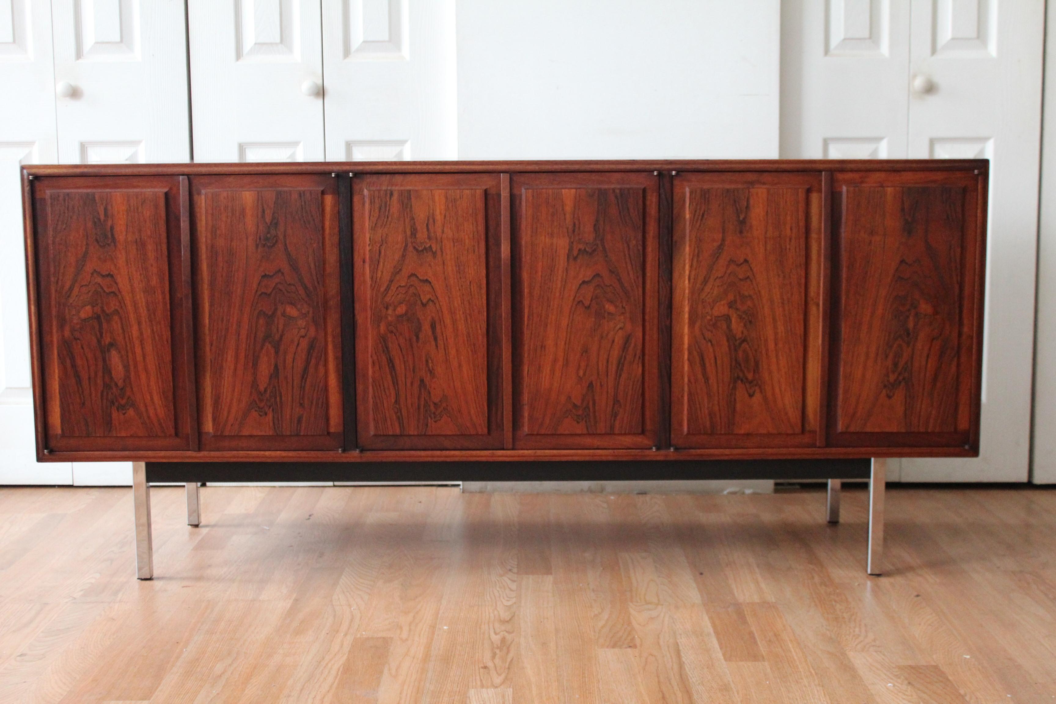 Jack Cartwright for Founders Rosewood Credenza. 3 sets of double doors, three dove-tailed pull out drawers with ample storage beneath. Case sits on squared chrome legs. Original finish. Exquisite.