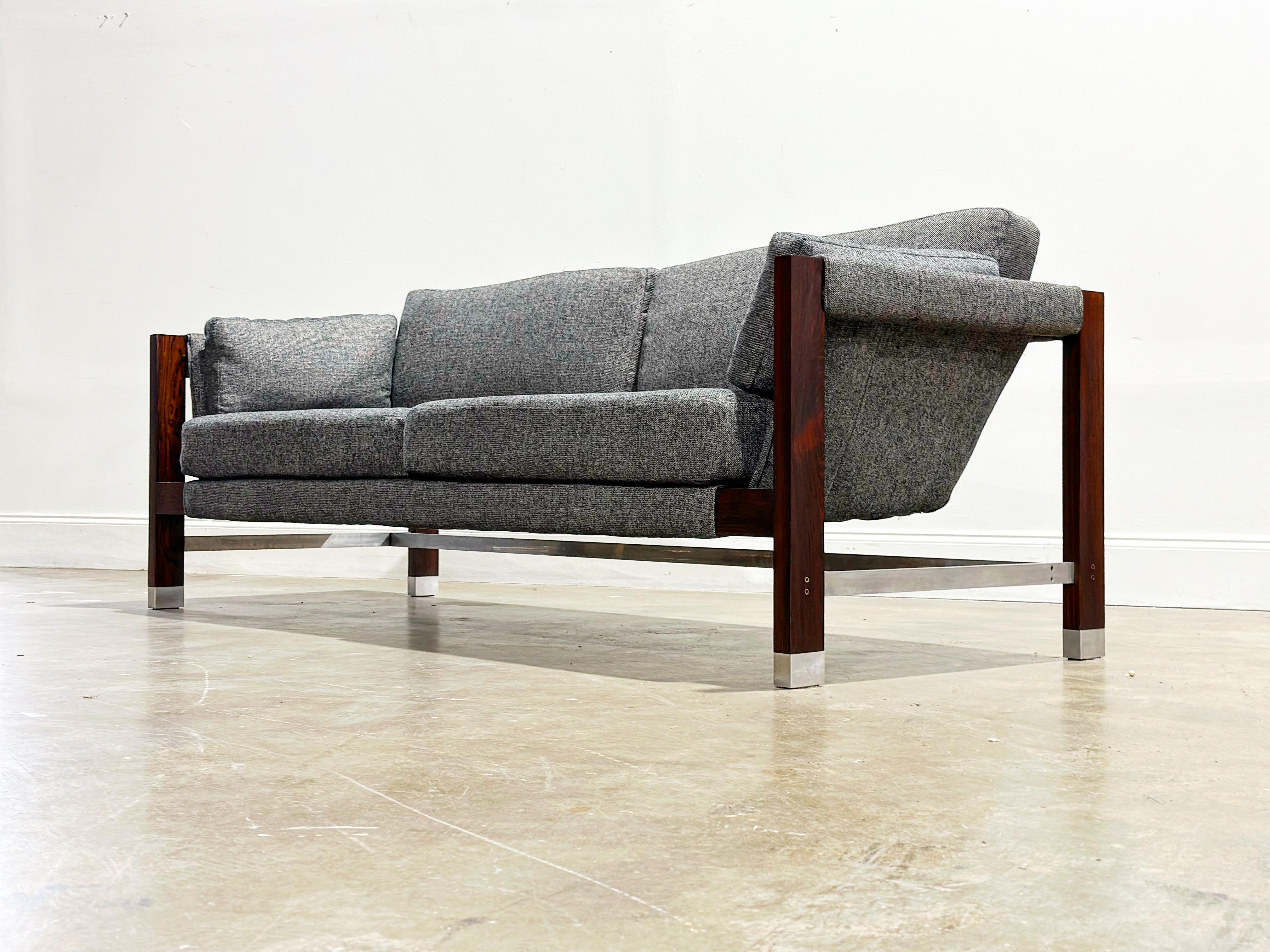 Rare open frame floating sling sofa by Jack Cartwright for Founders Furniture, circa 1960's. Minimalist rosewood and aluminum frame. Absolutely stunning from any angle. Perfect statement piece to anchor a room. 

Fully restored with all new soft