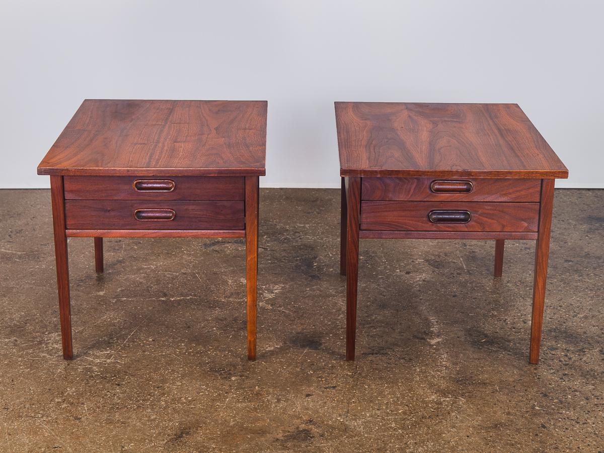 Sold as a pair. Gorgeous midcentury walnut end tables by Jack Cartwright for Founders. Well crafted, two-drawer matching tables with an exquisite walnut grain. The tables are in excellent condition. Walnut wood is gleaming with beautiful hand-carved
